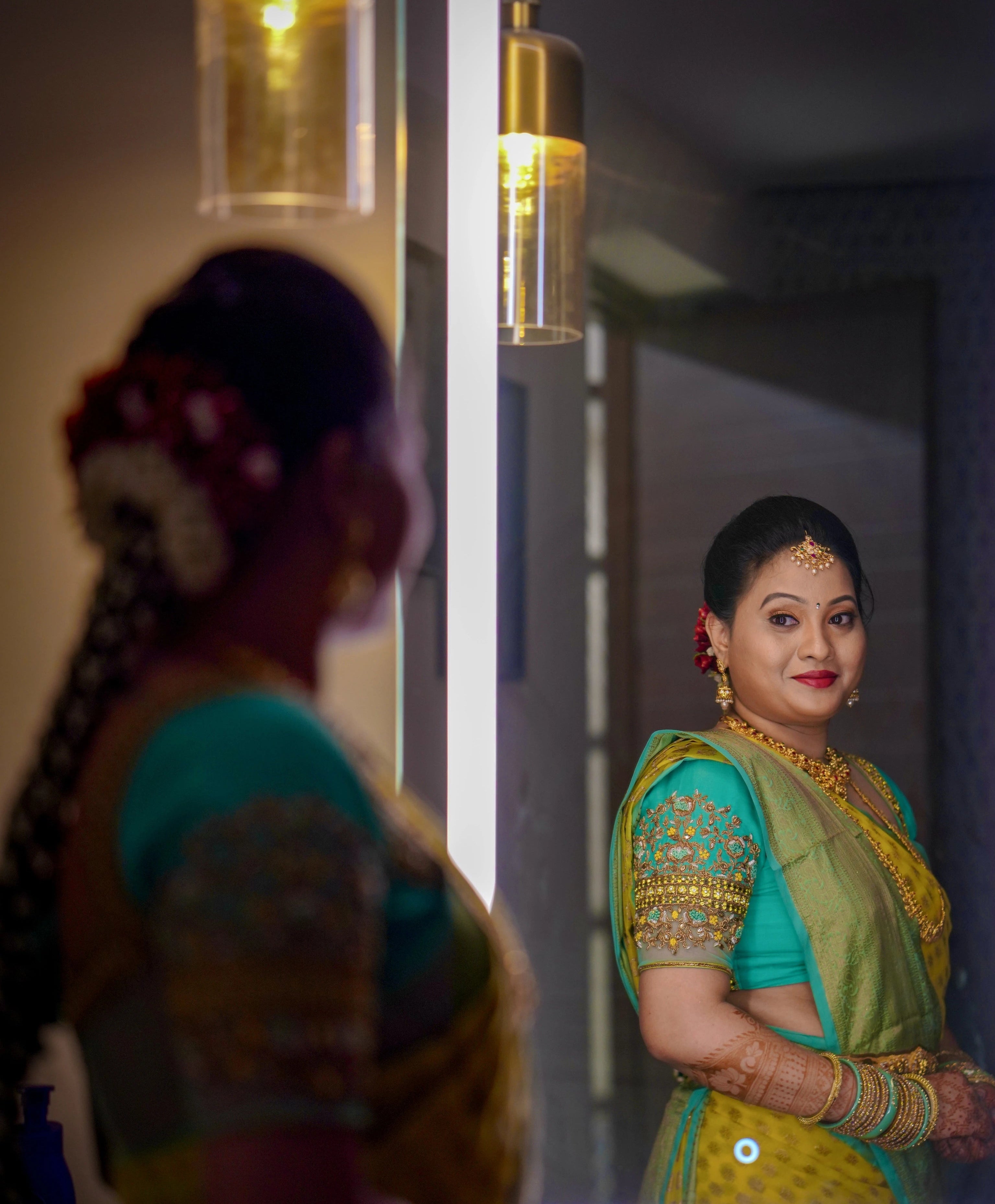 Bride from Seattle posing in the mirror in an aquamarine blouse designed by Archana Karthick