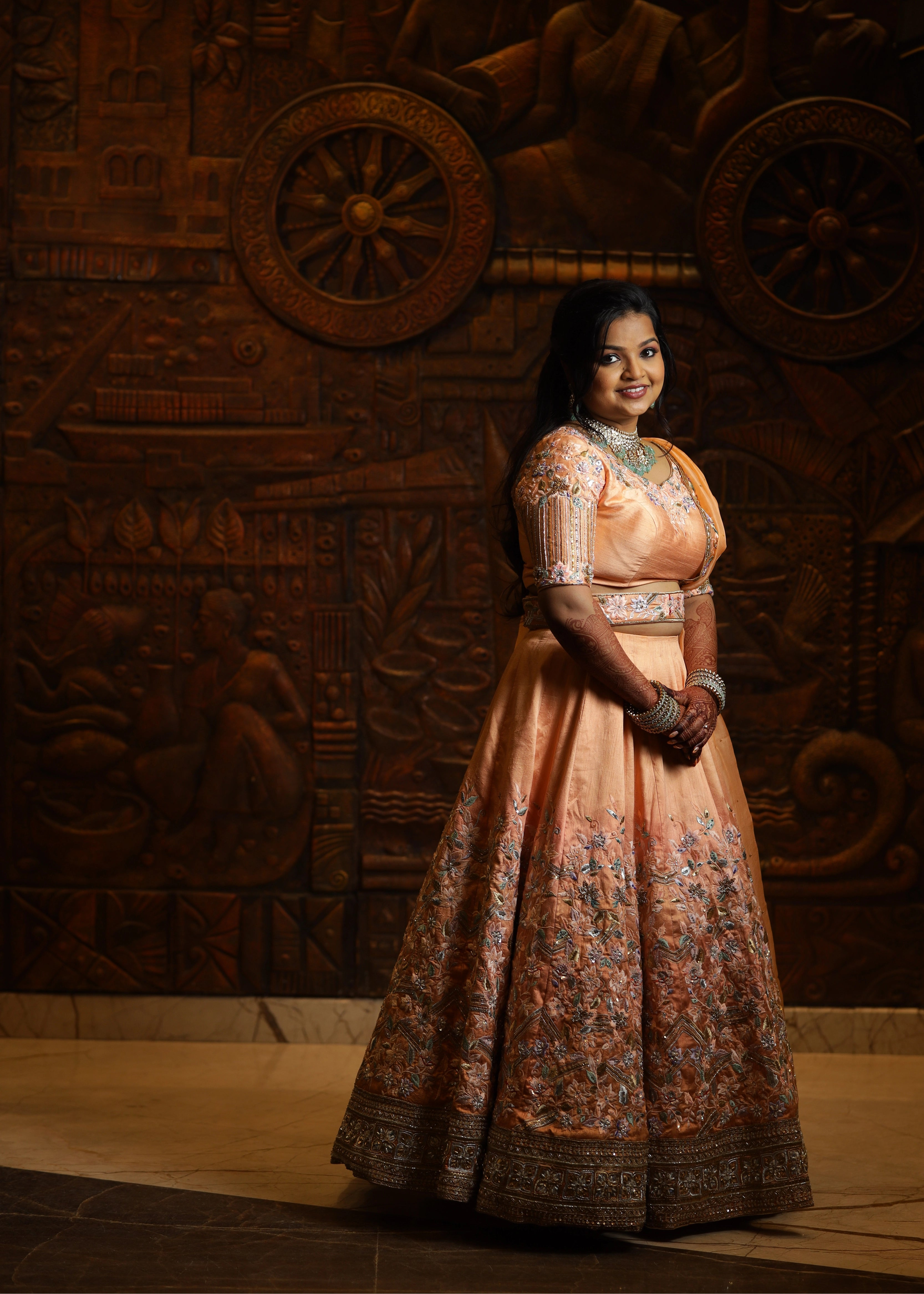 Bride from Singapore looking good in a handcrafted peach lehenga designed by Archana Karthick