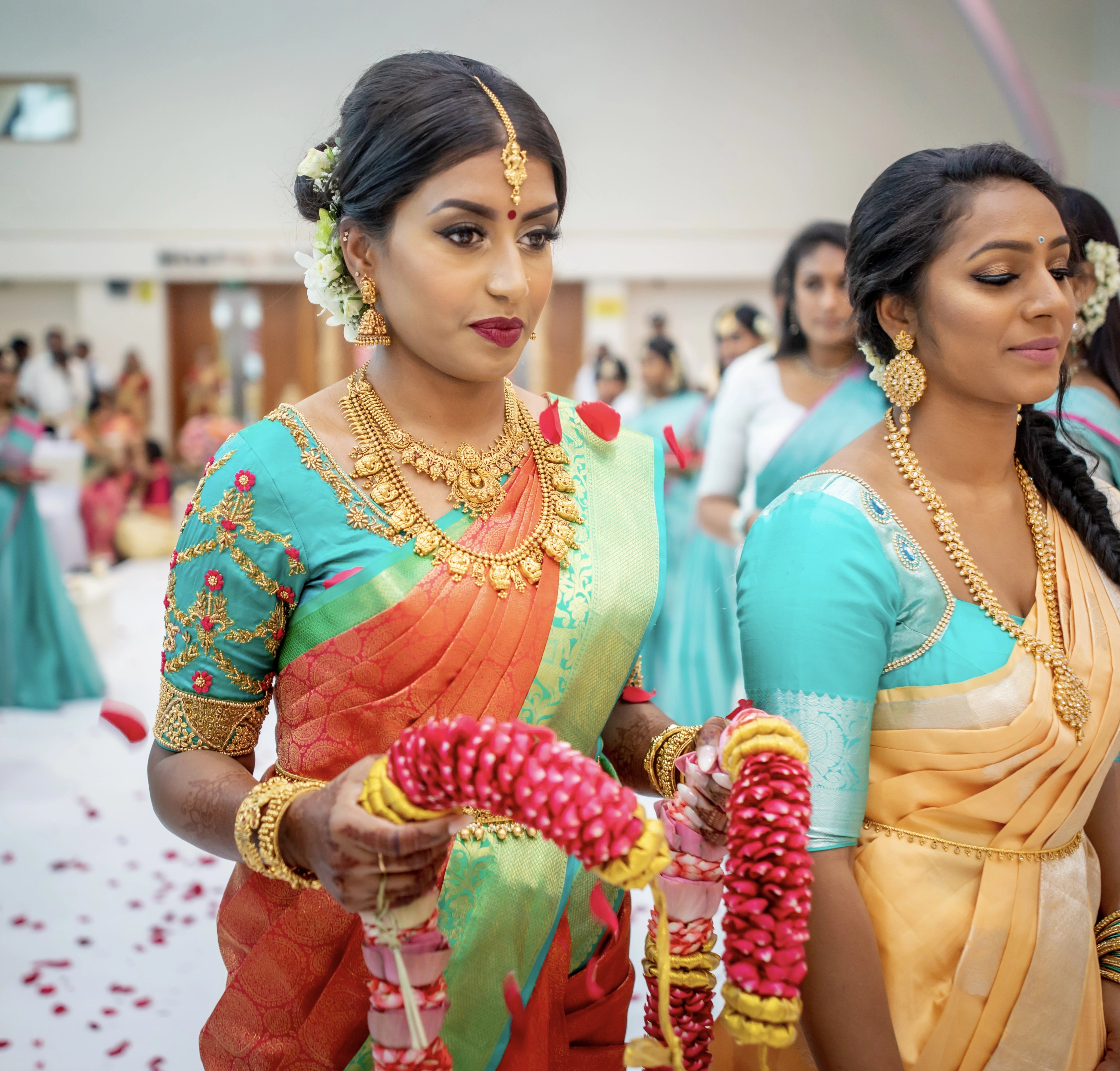 Bride from UK with garland in an aquamarine silk blouse for her wedding. Handcrafted intricately with beads, zardozi and resham knot work by team Archana Karthick.
