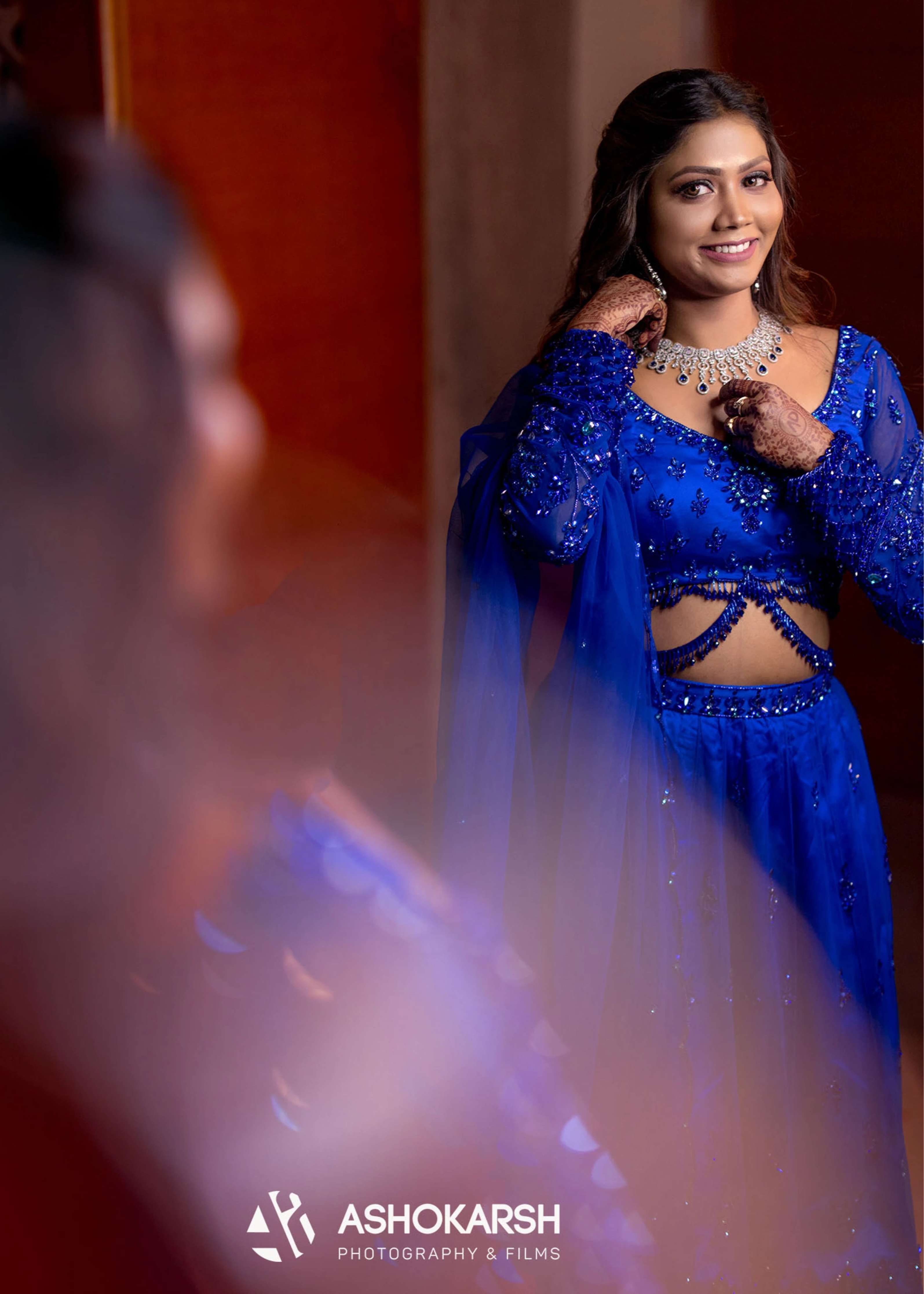 Bride from USA posing in the mirror in a concept blue lehenga handcrafted intricately with rhinestones, crystal beads, cutdanas and sequins.