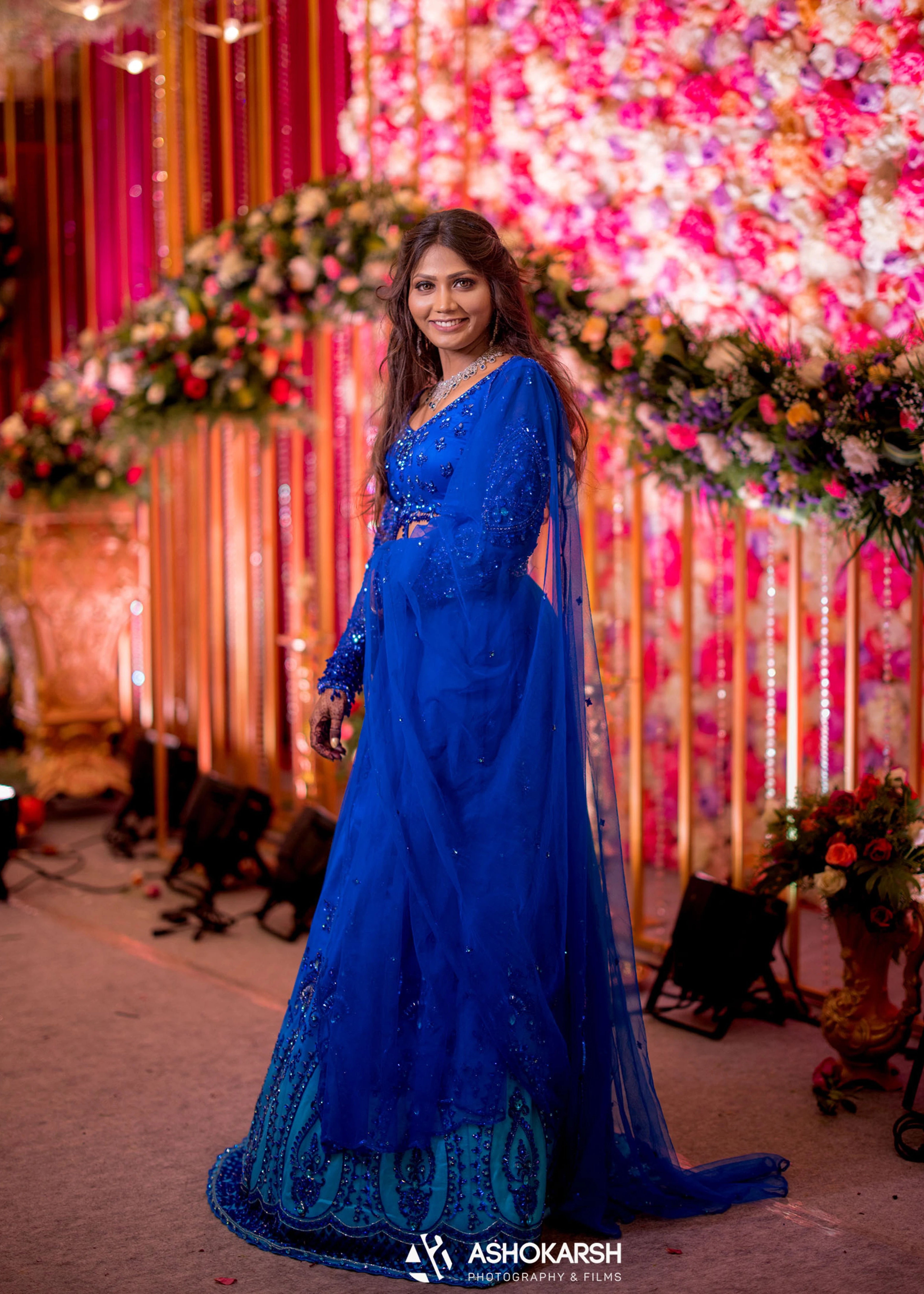 Bride from USA smiling in a concept blue lehenga handcrafted intricately with rhinestones, crystal beads, cutdanas and sequins.