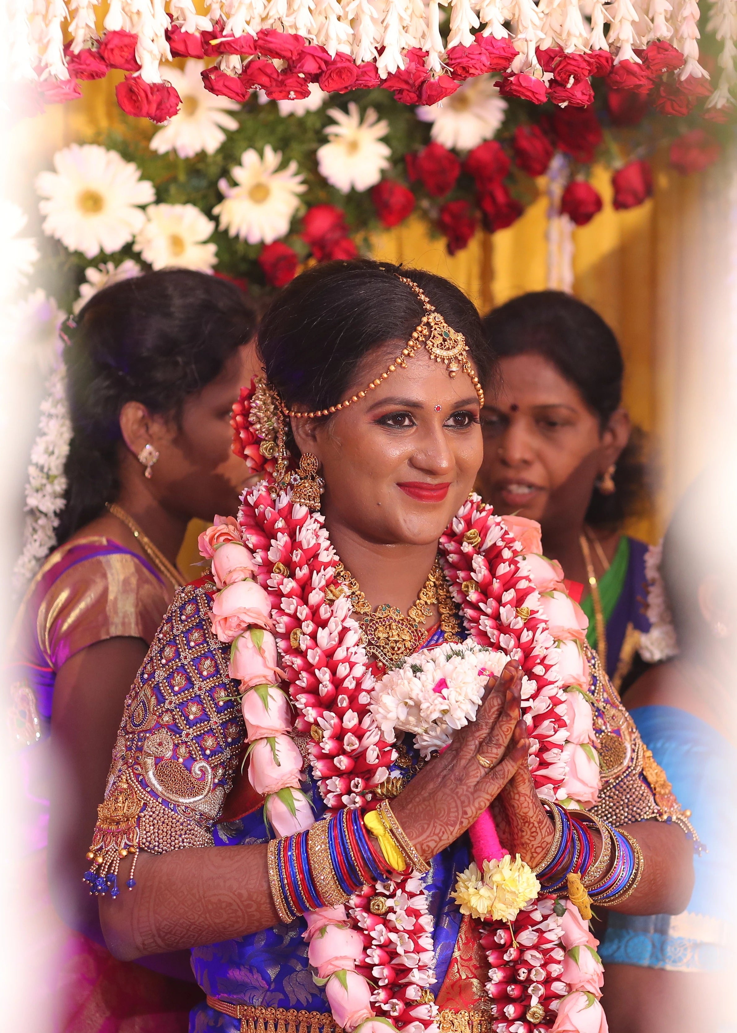 Bride in a concept peacock blouse in blue and red silk, handcrafted with zardozi, beads, resham knot work and goddess pendant on sleeves.