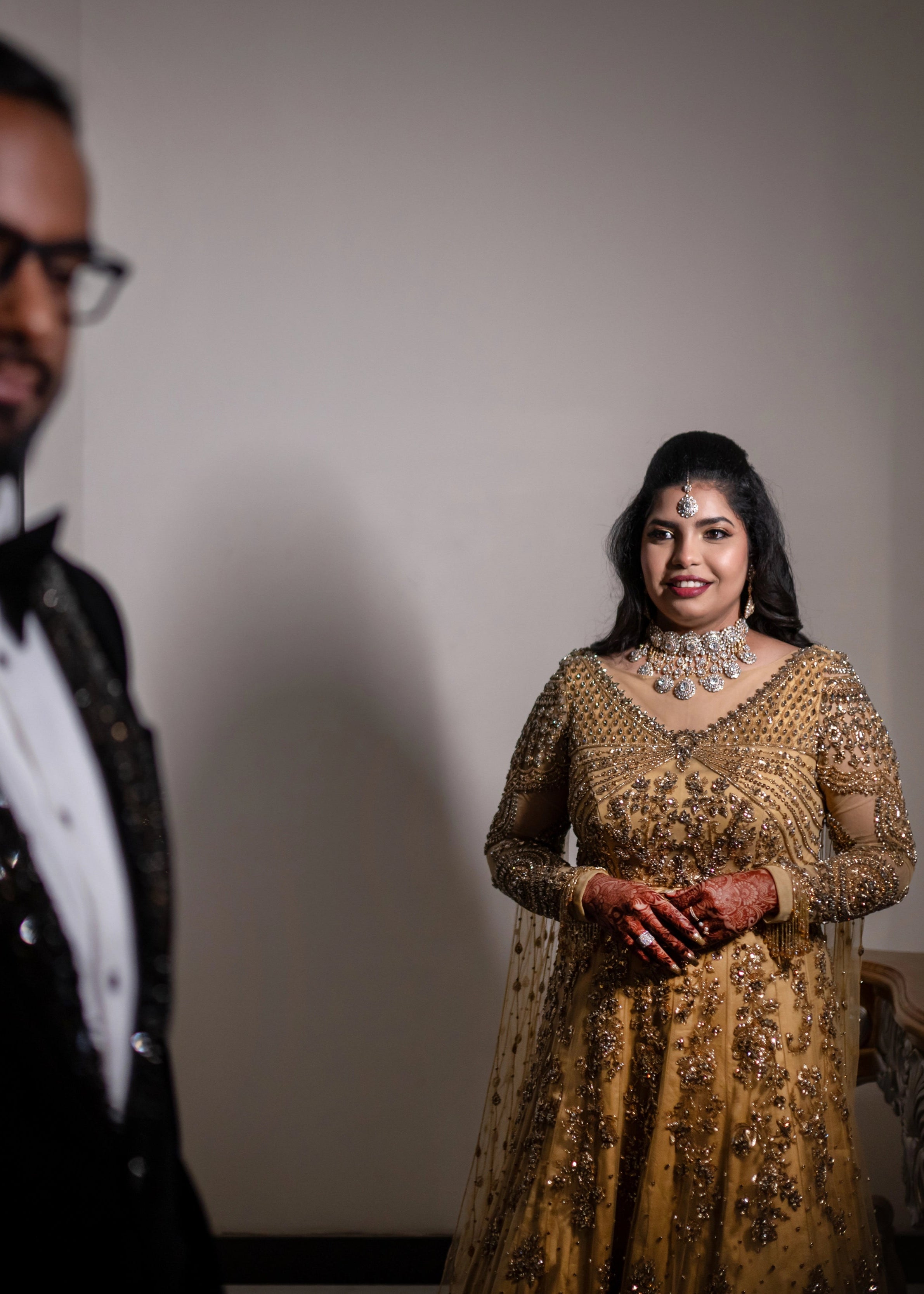 Bride in a gold gown in tulle designed by Archana Karthick and handcrafted with rhinestones and cut dana with floral and geometric motifs.