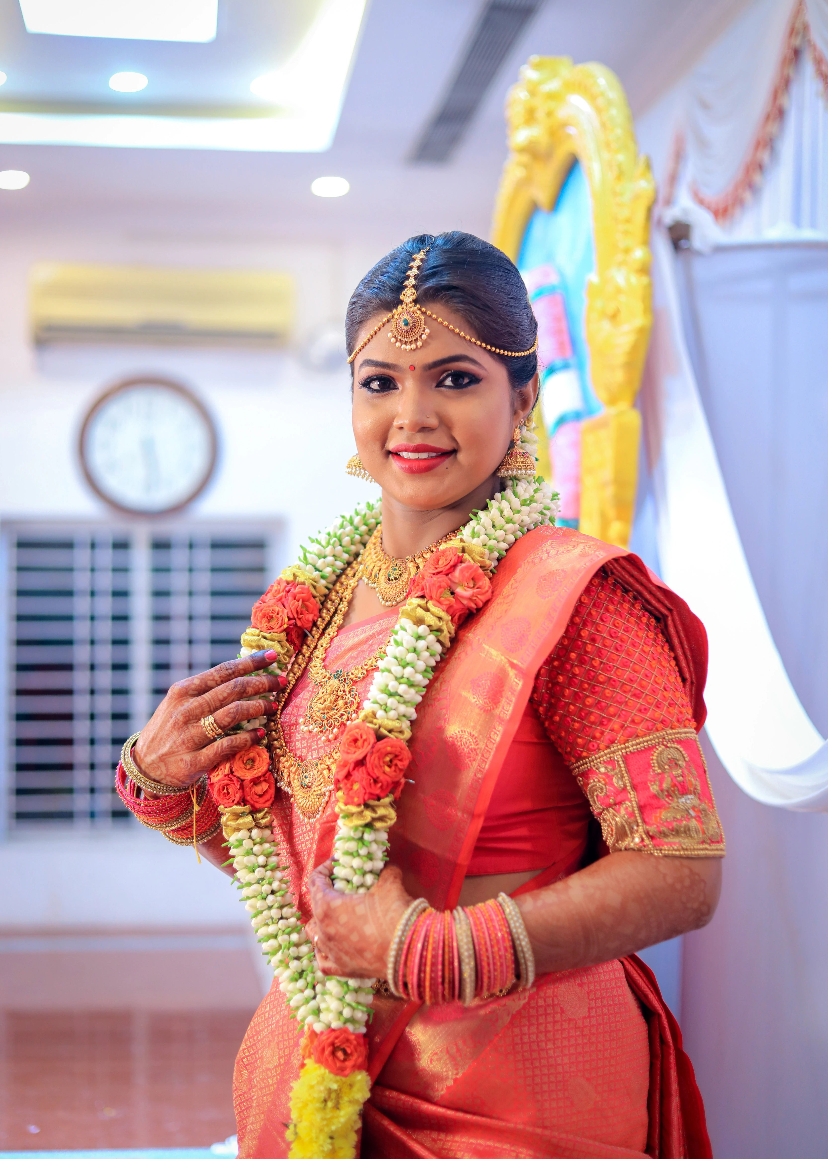 Bride in a handcrafted orange silk blouse designed by Archana Karthick