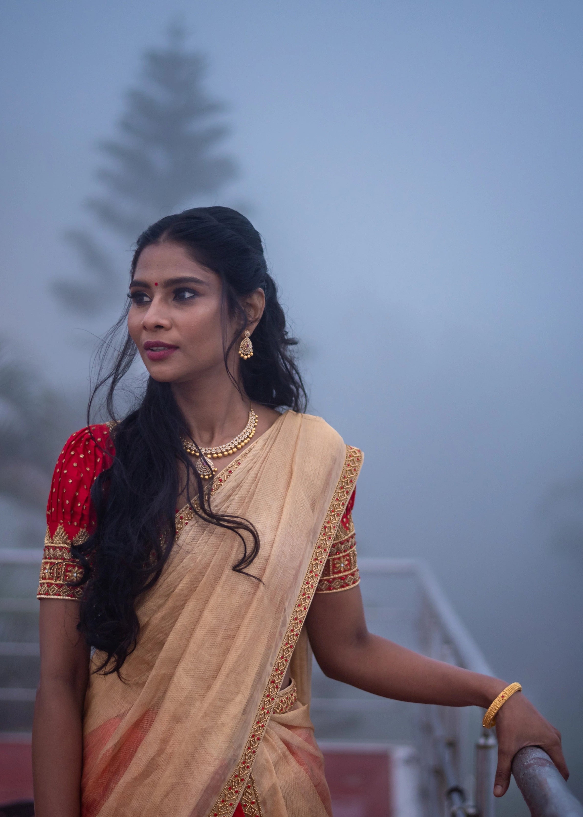 Bride in a handcrafted red silk half saree with katori cut blouse has intricate zardozi and stone work.