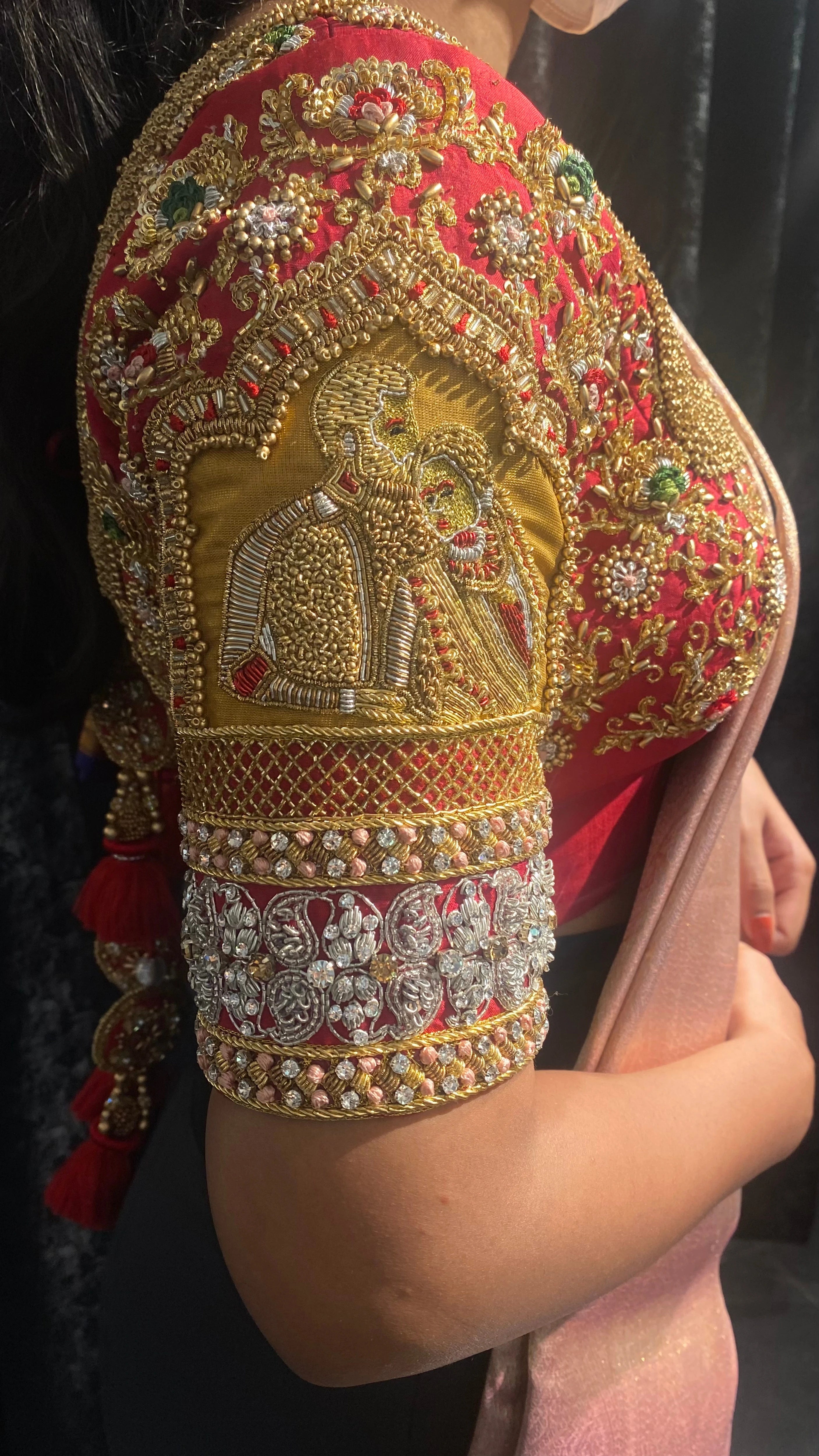 Bride in a red silk blouse during fittings, handcrafted by team Archana Karthick.
