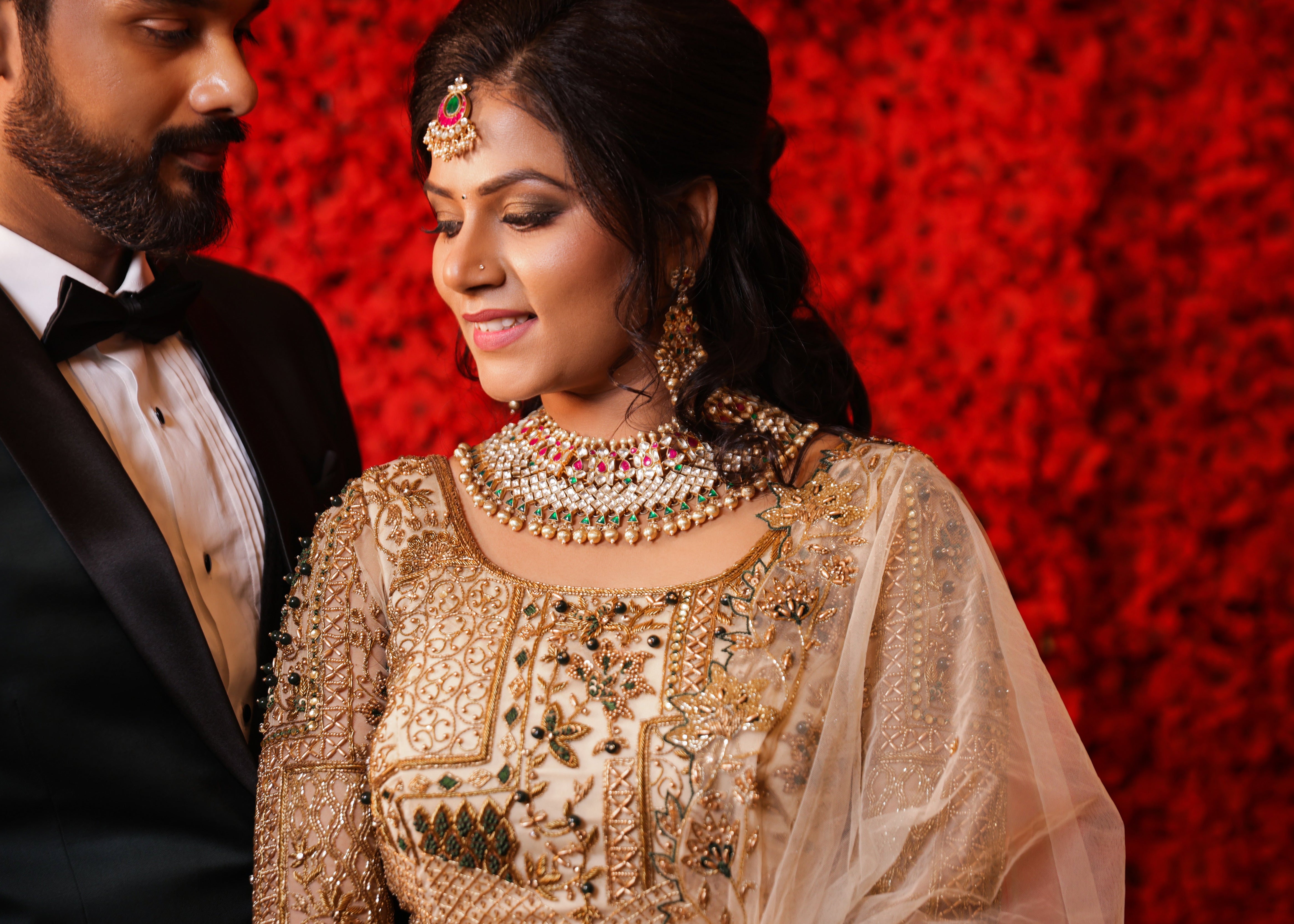 Bride in an ivory lehenga in tulle with cut worked dupatta and handcrafted intricately with stones, zardozi, reshams knot work, beads and cutdanas. Designed by Archana Karthick