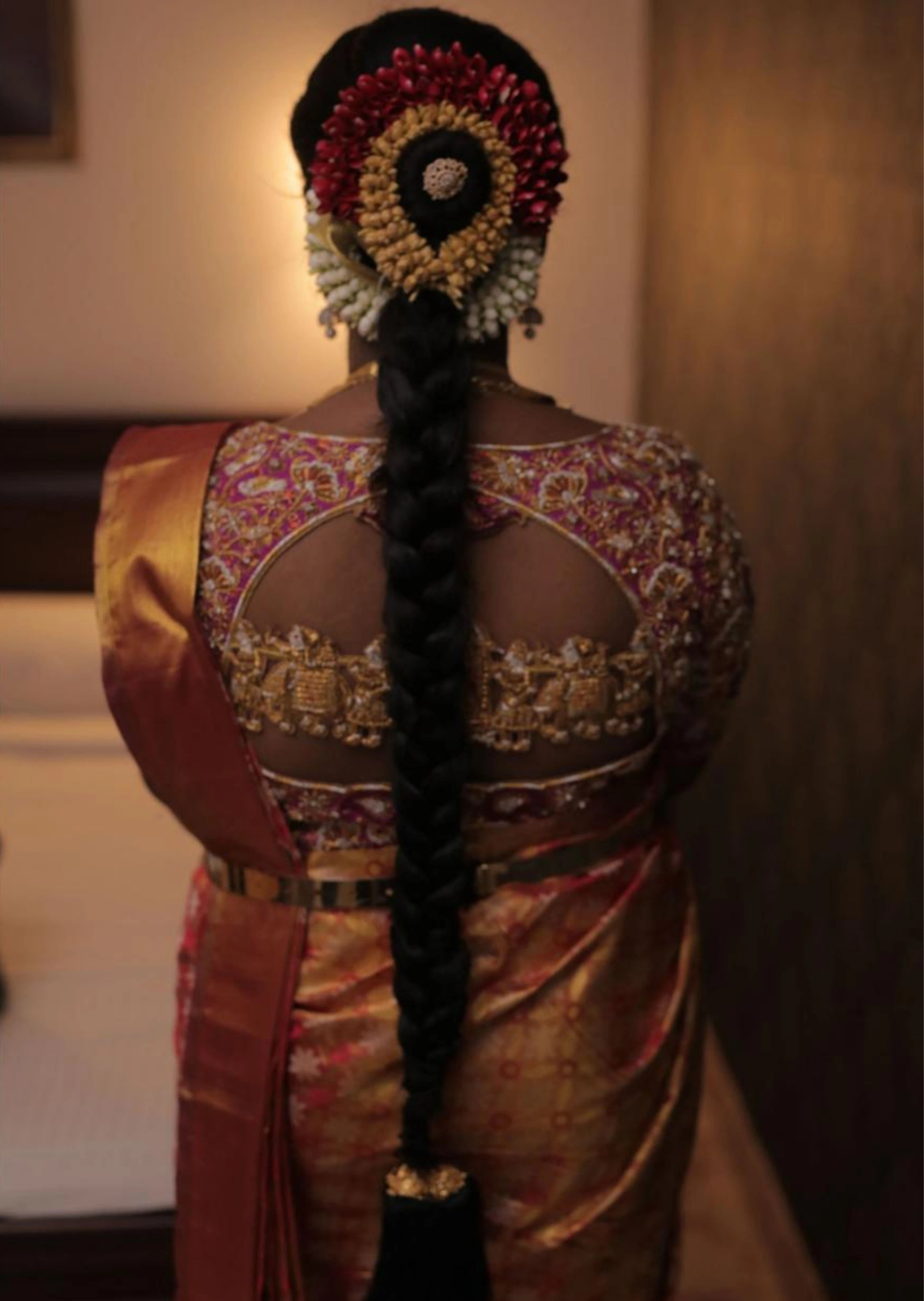 Bride in handcrafted palanquin concept magenta pink silk blouse with zardozi, kemp stones, pearls and resham knot work and goddess pendants on each sleeve. Designed by Archana Karthick