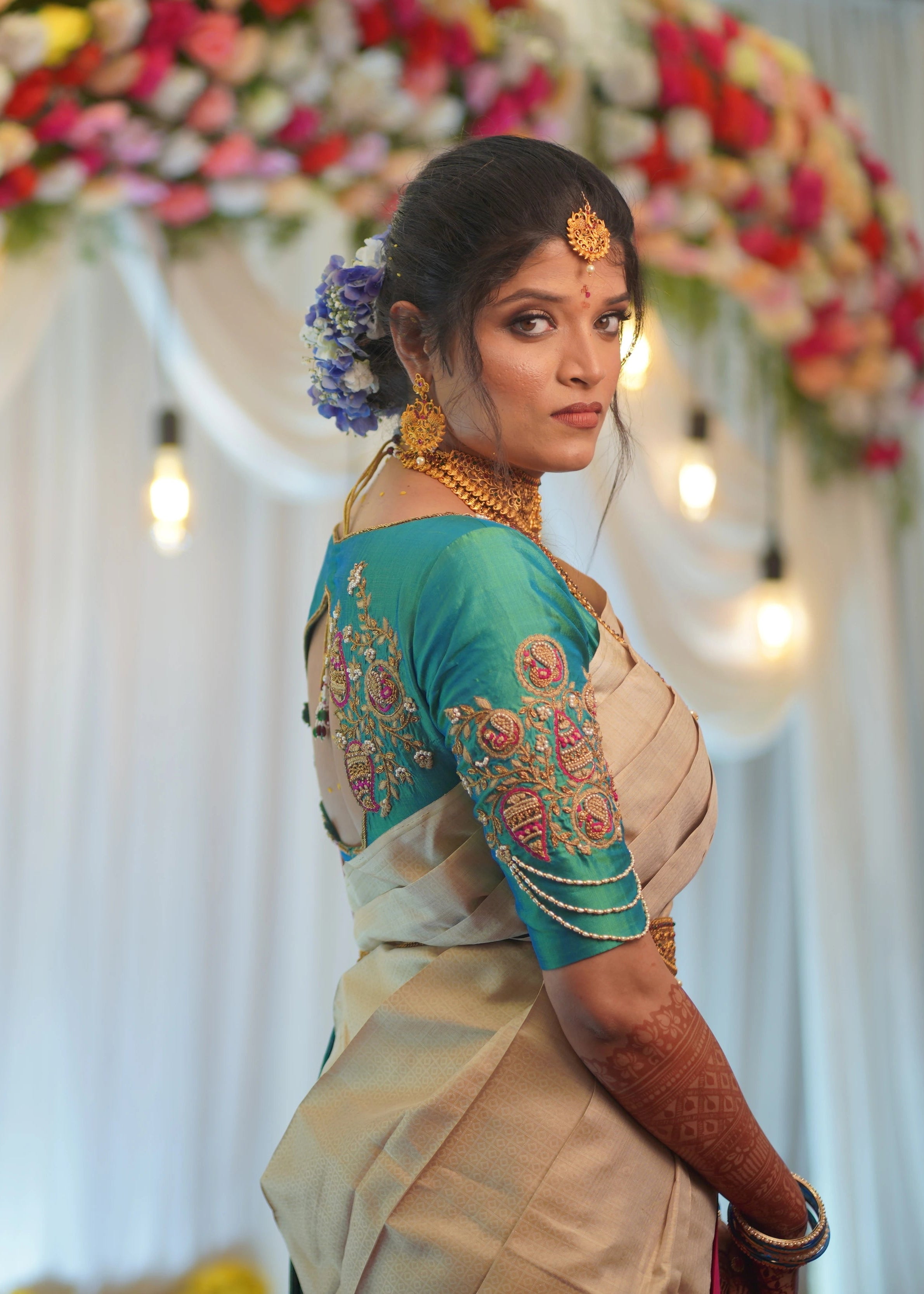 Bride in handcrafted teal silk blouse with paisley motifs designed by Archana Karthick