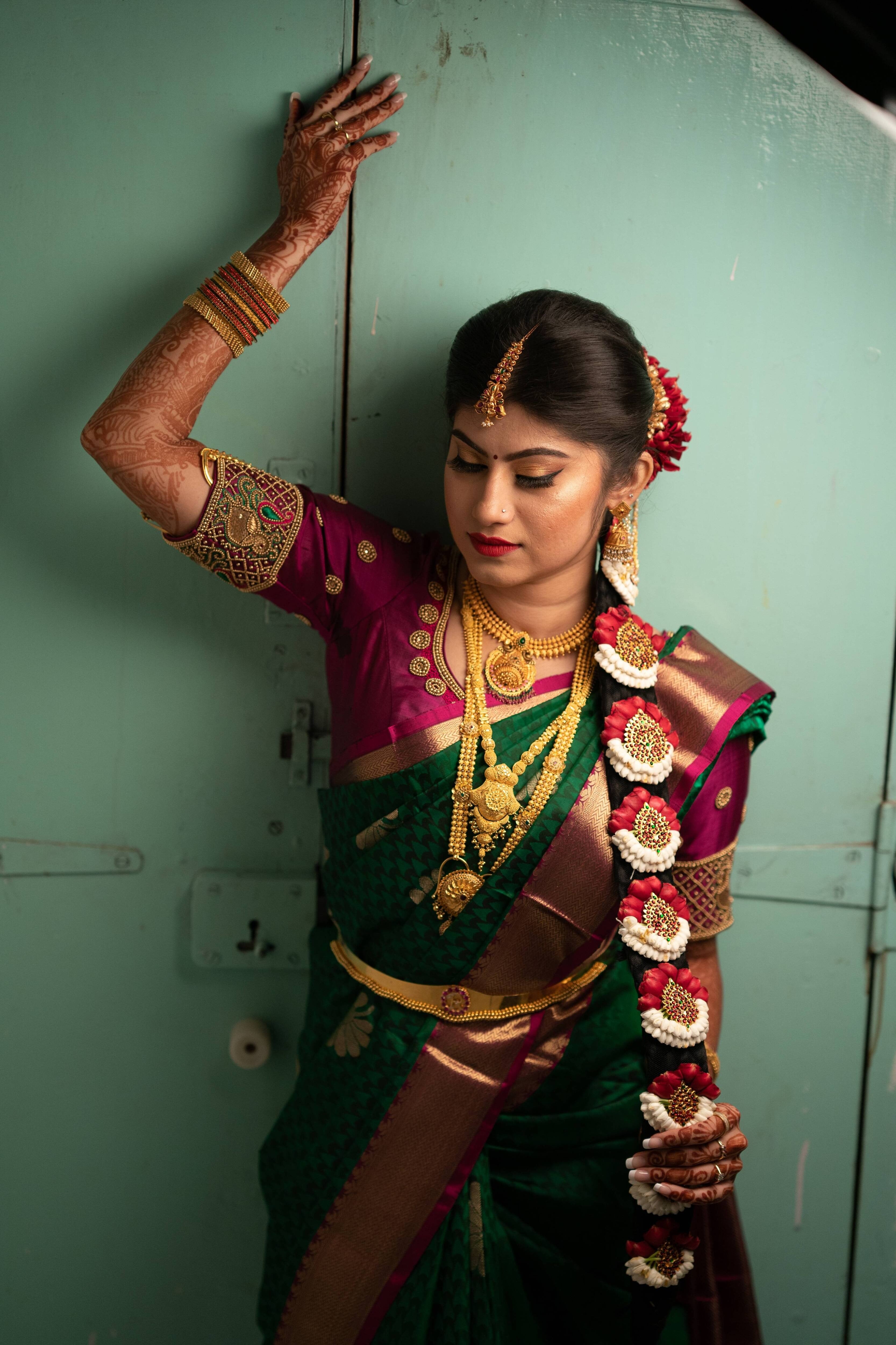 Bride Vandita from Bagalore is seen here in our silk aubergine colore blouse.This is designed for her engagement. Resham, zardozi, beads and mirror work techniques used on the blouse. The right arm is lifted up by the bride which clearly shows the sleeve and the intricacy.