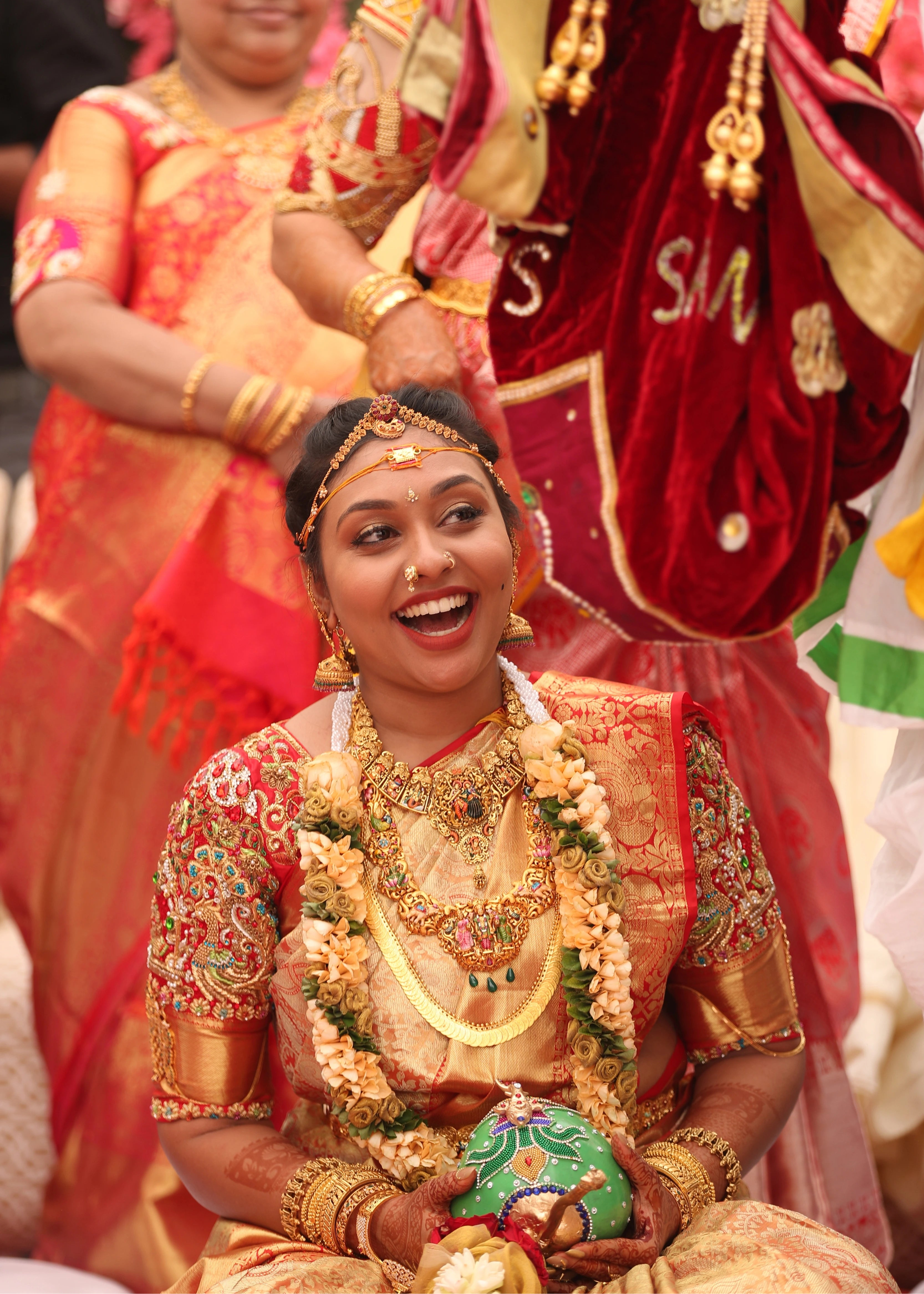 Bride laughing in a bride and groom concept red silk blouse is a handcrafted with zardozi, rhinestones, pearls and beads. Designed by Archana Karthick