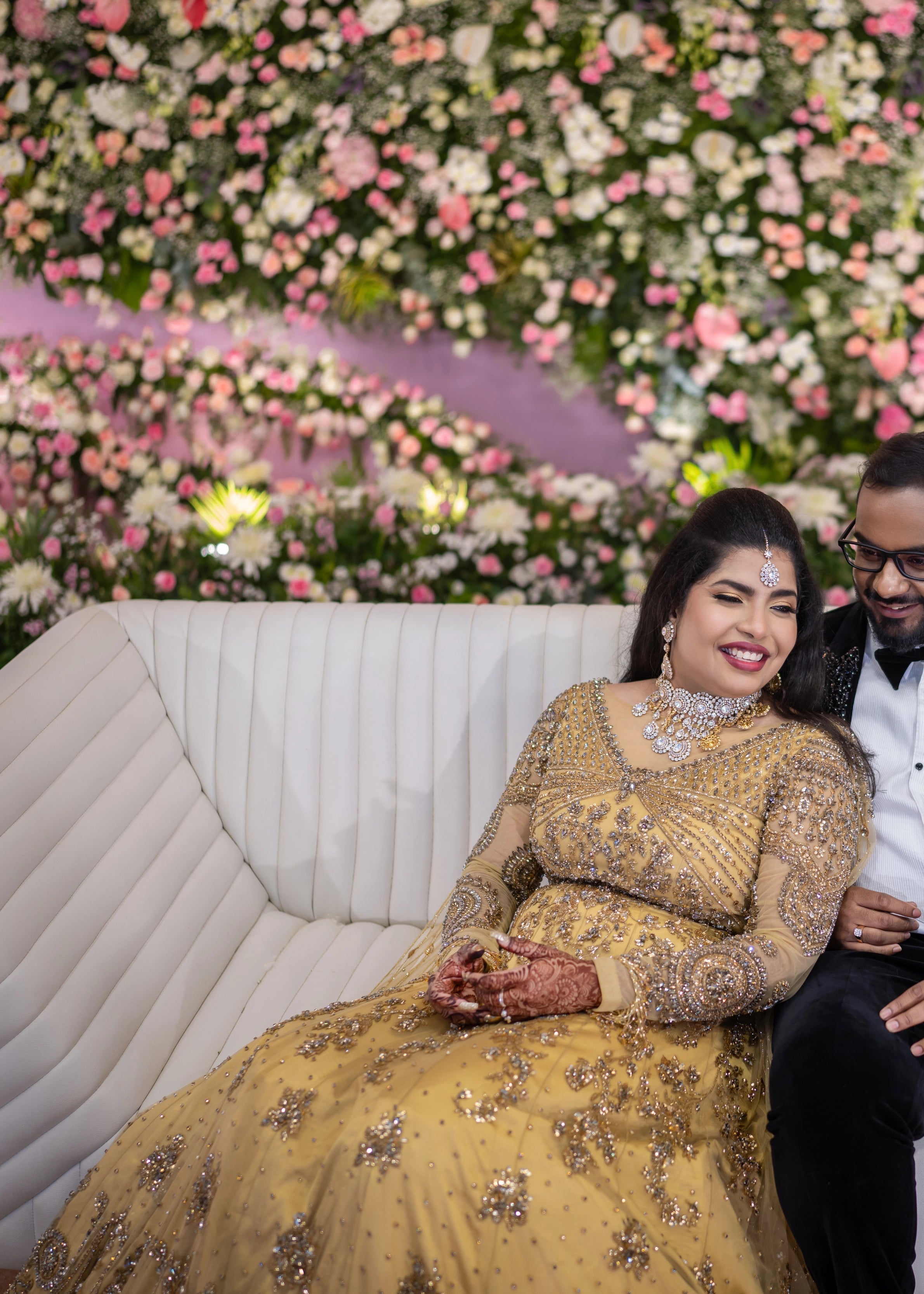 Bride laughing in a gold gown in tulle designed by Archana Karthick and handcrafted with rhinestones and cut dana with floral and geometric motifs.