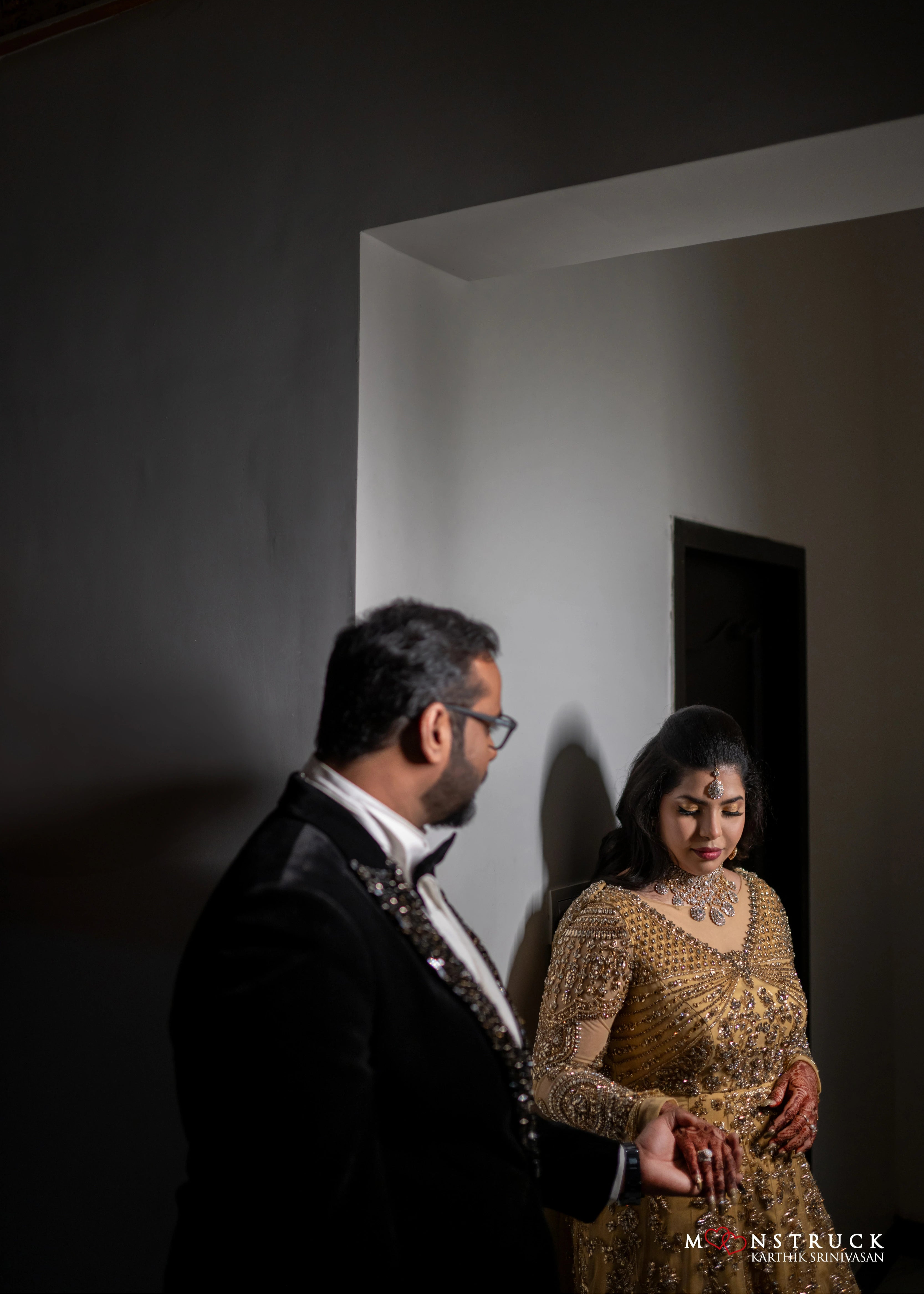 Bride looking down in a gold gown in tulle designed by Archana Karthick and handcrafted with rhinestones and cut dana with floral and geometric motifs.