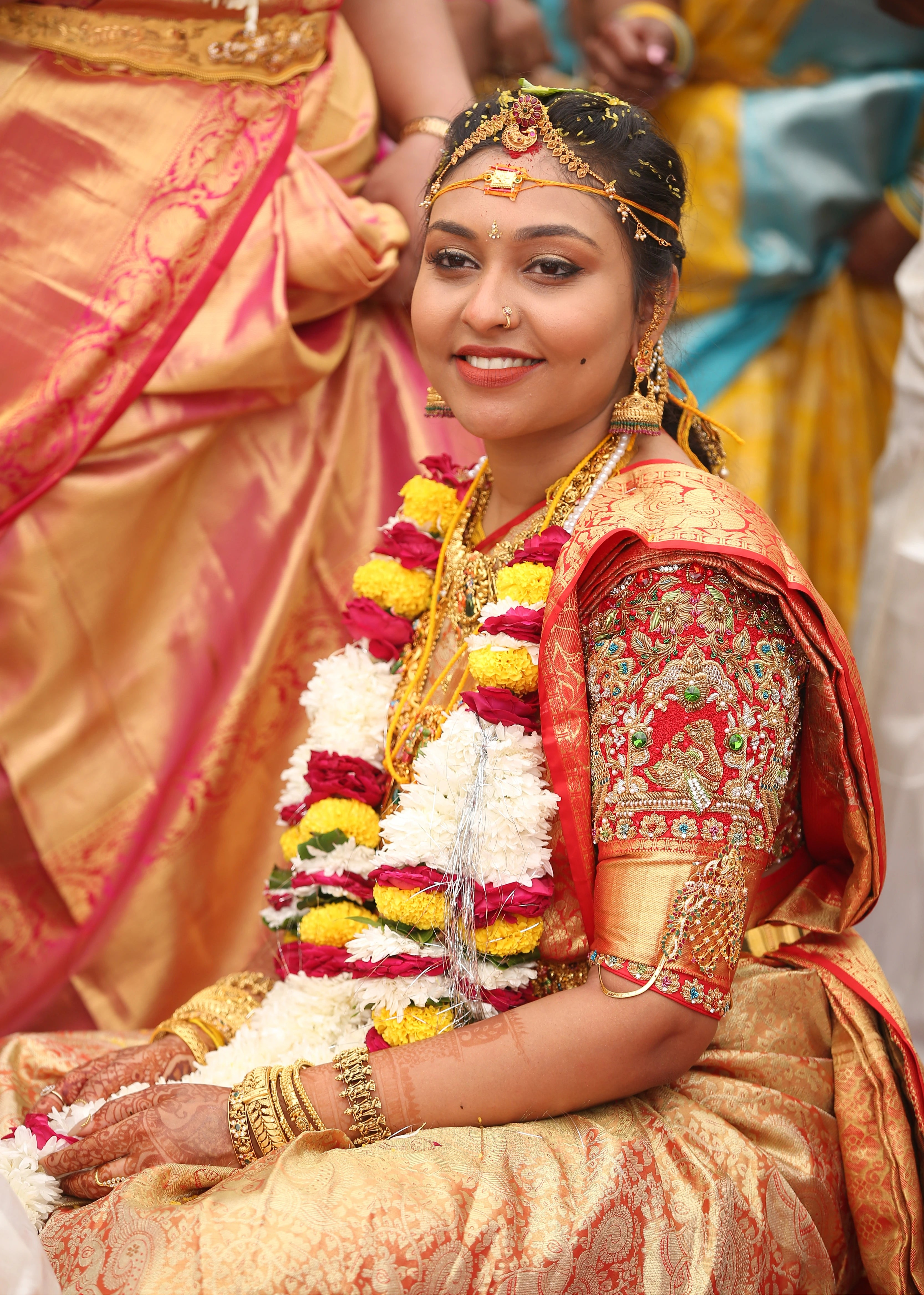Bride looking in a bride and groom concept red silk blouse is a handcrafted with zardozi, rhinestones, pearls and beads. Designed by Archana Karthick