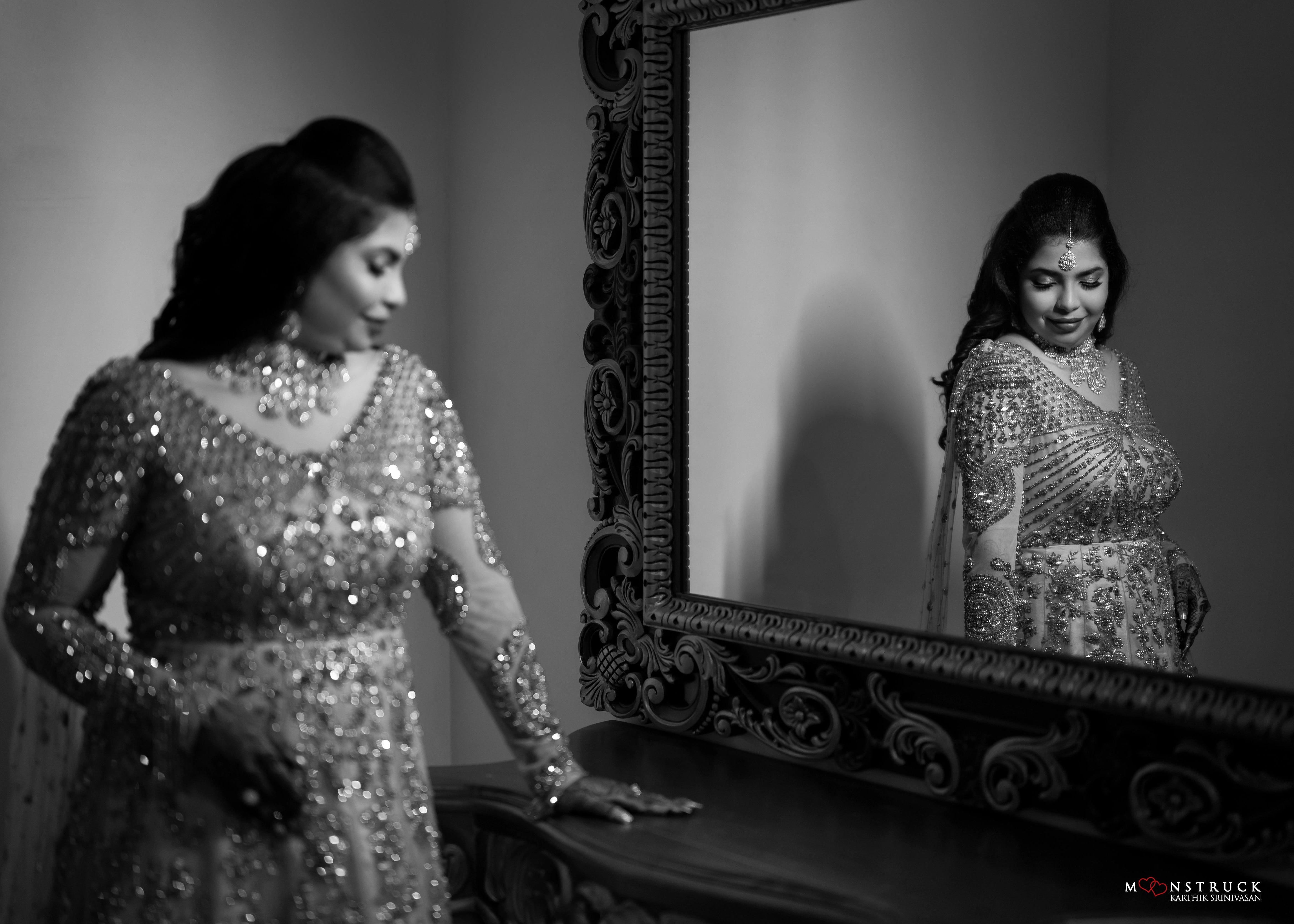 Bride posing for a reflection in a gold gown in tulle designed by Archana Karthick and handcrafted with rhinestones and cut dana with floral and geometric motifs.