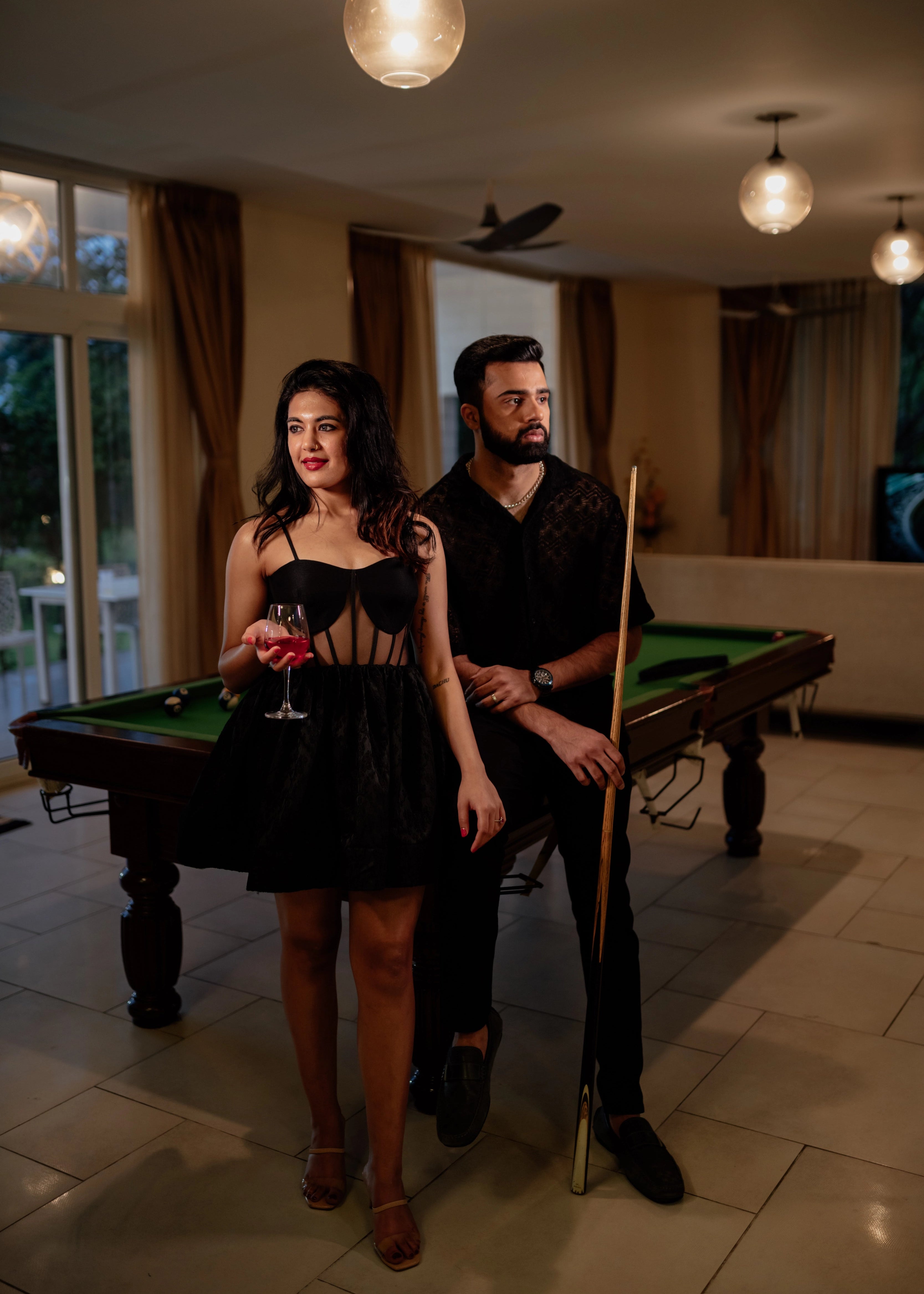 Bride posing in a black corset dress handcrafted in raw silk, tulle and jacquard. Designed by Archana Karthick