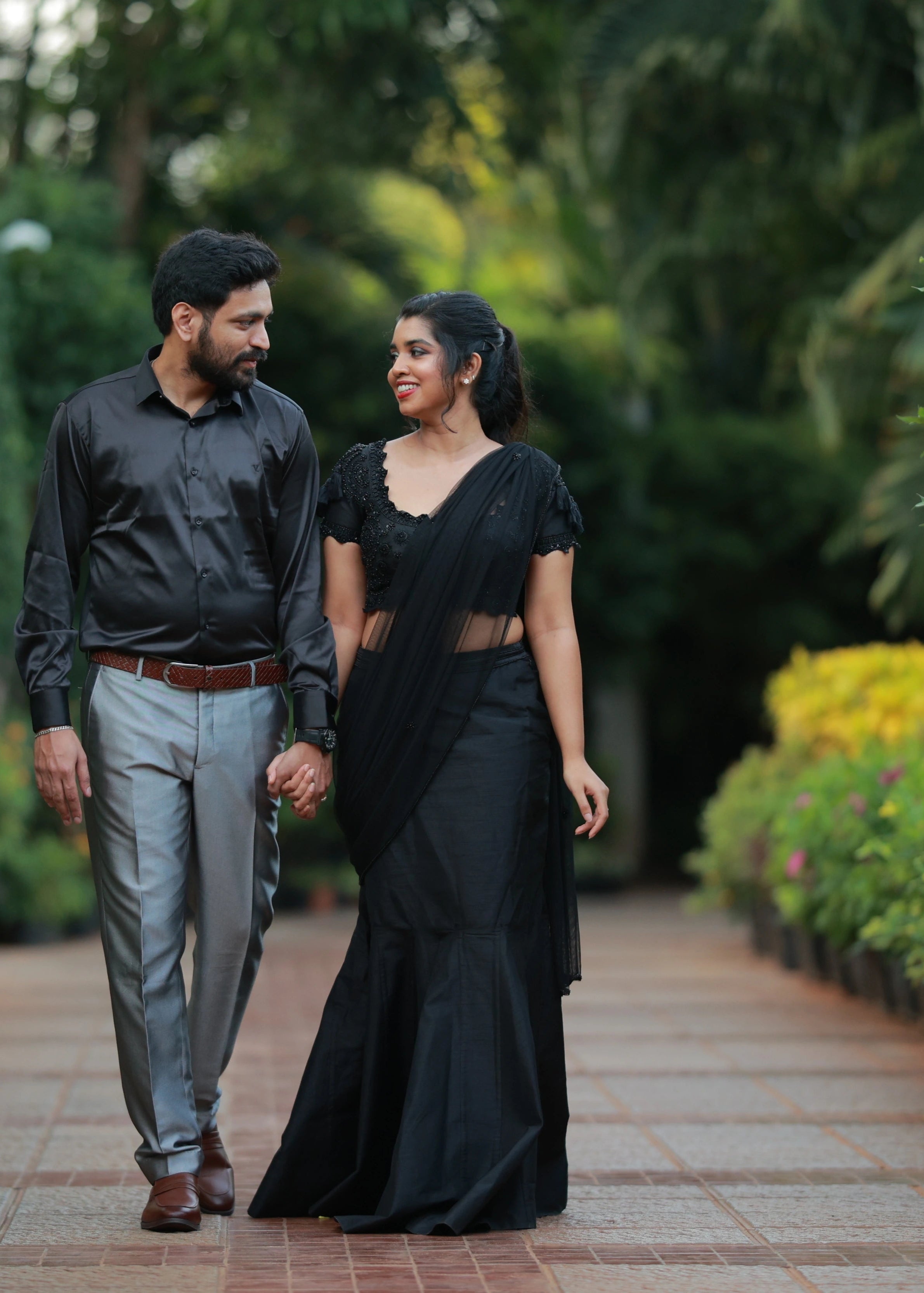 Bride posing in a black mermaid drape handcrafted with beads, cut dana, sequins, resham and handmade tassels to finish the look. Designed by Archana Karthick.
