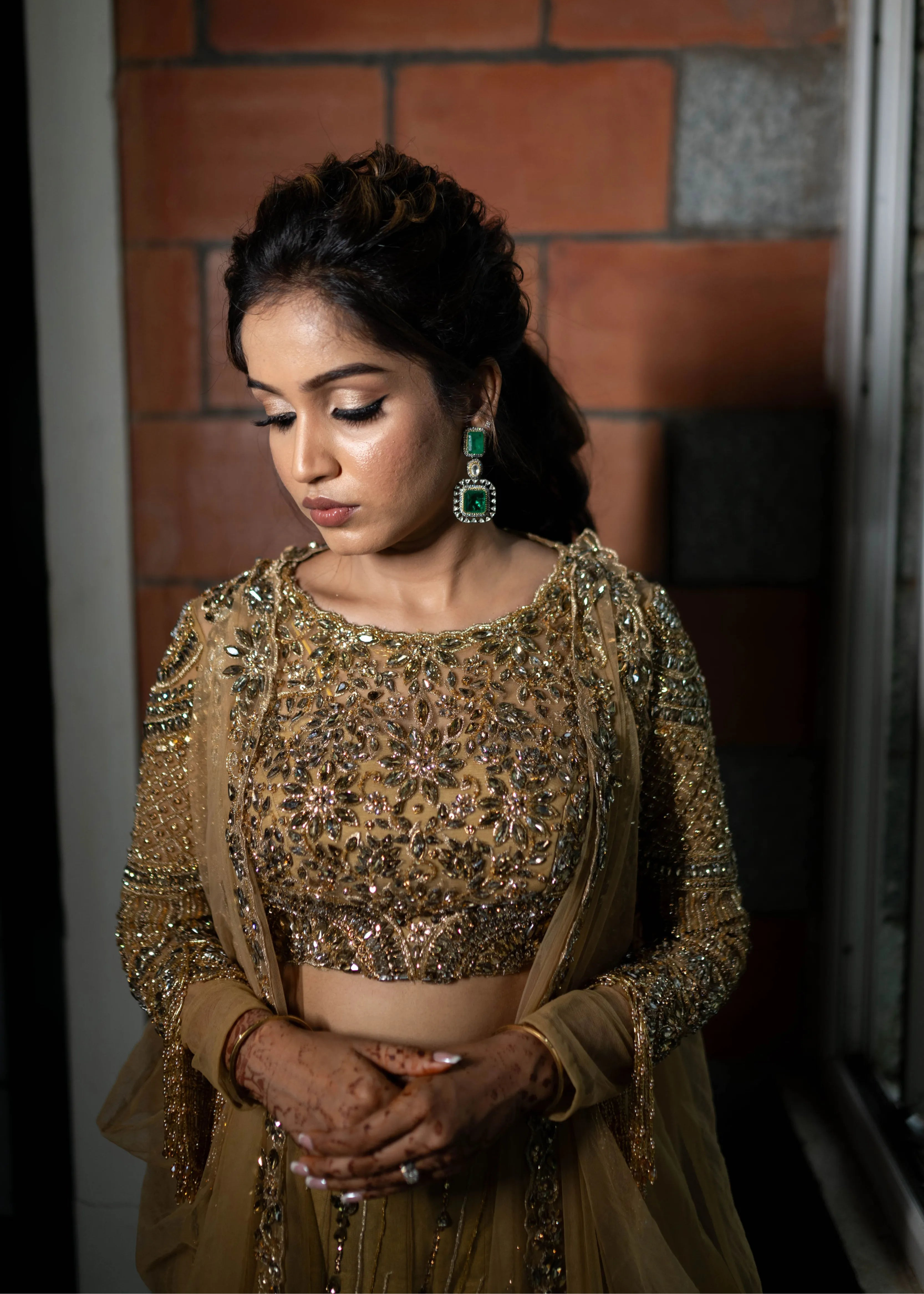 Bride posing in a concept gold lehenga in tulle designed by Archana Karthick is handcrafted intricately with rhinestones, crystal beads, cutdanas and sequins.