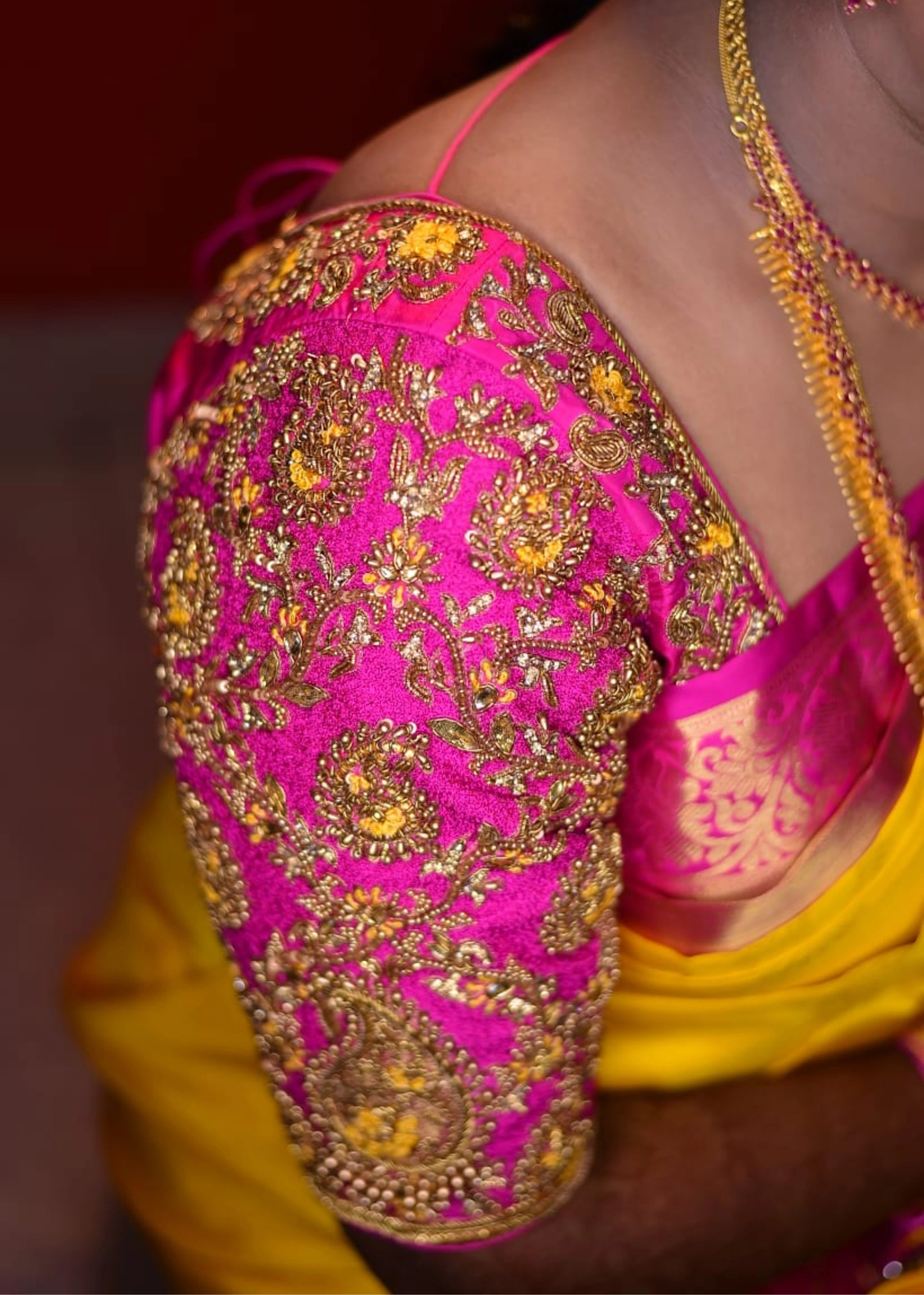 Bride posing in a handcrafted pink raw silk blouse with beads, kundan, zardozi and resham knot work with paisley motifs designed by Archana Karthick