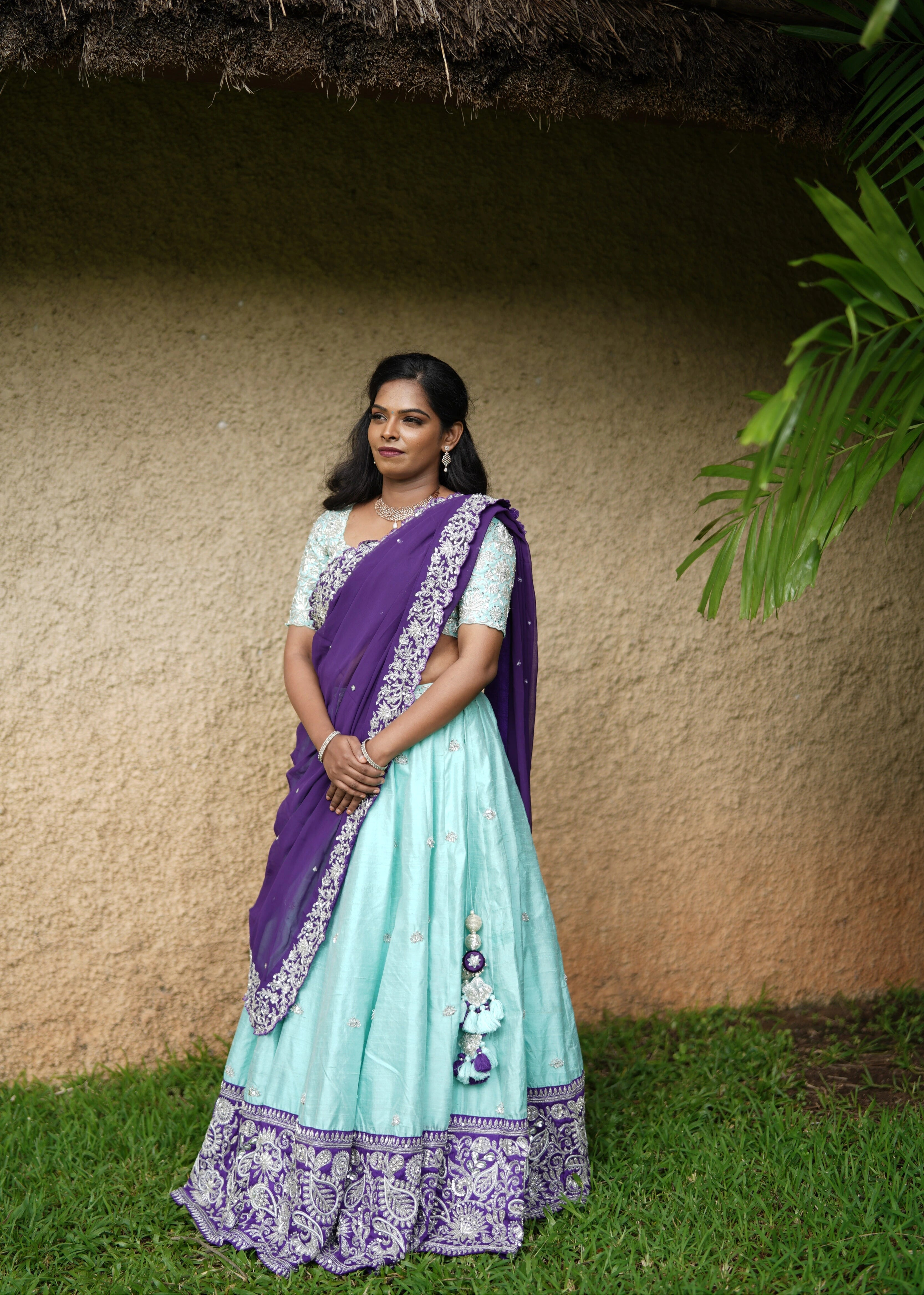 Bride posing in blue and purple rawsilk lehenga designed by Archana Karthick