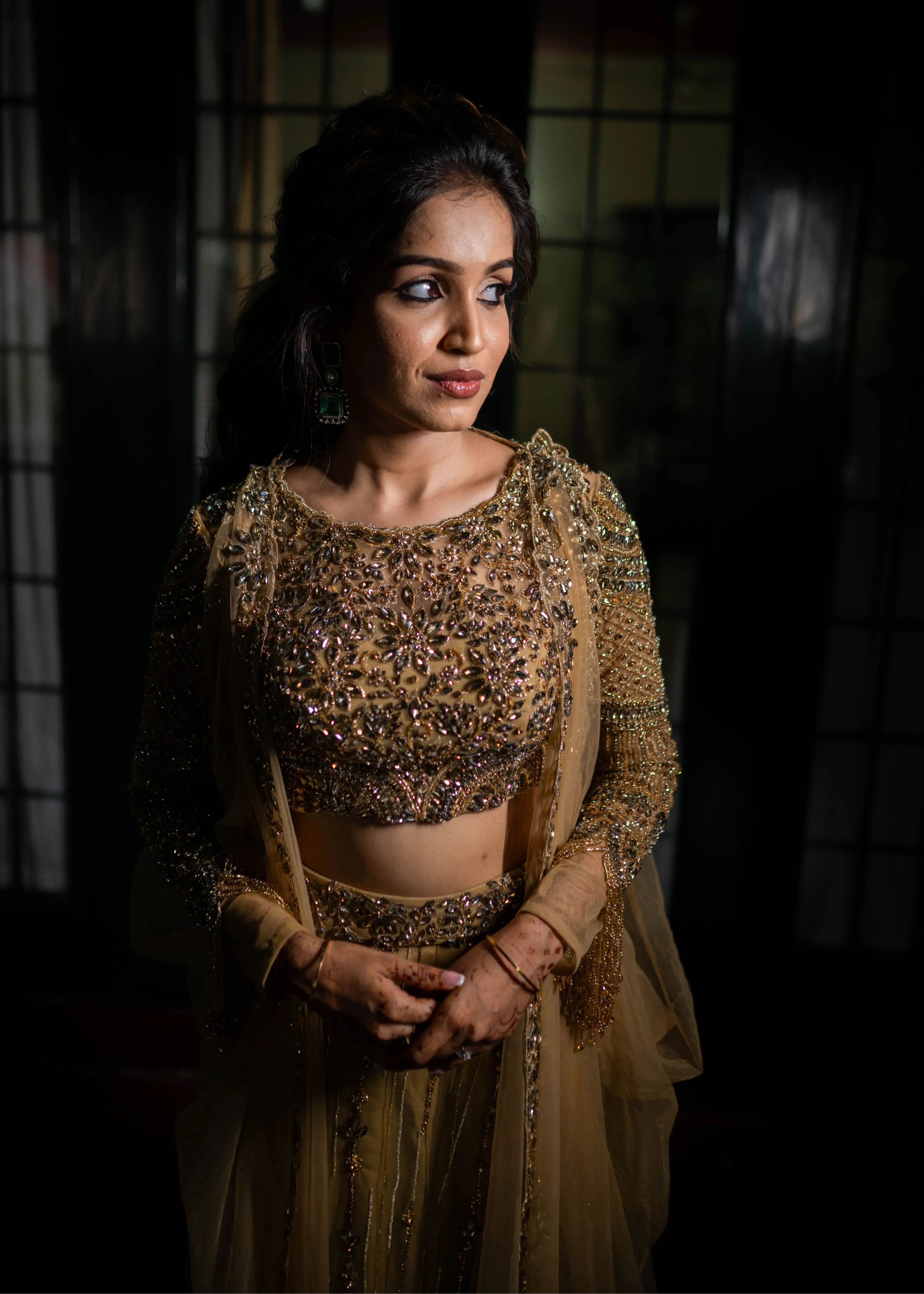 Bride smiling in a concept gold lehenga in tulle designed by Archana Karthick is handcrafted intricately with rhinestones, crystal beads, cutdanas and sequins.
