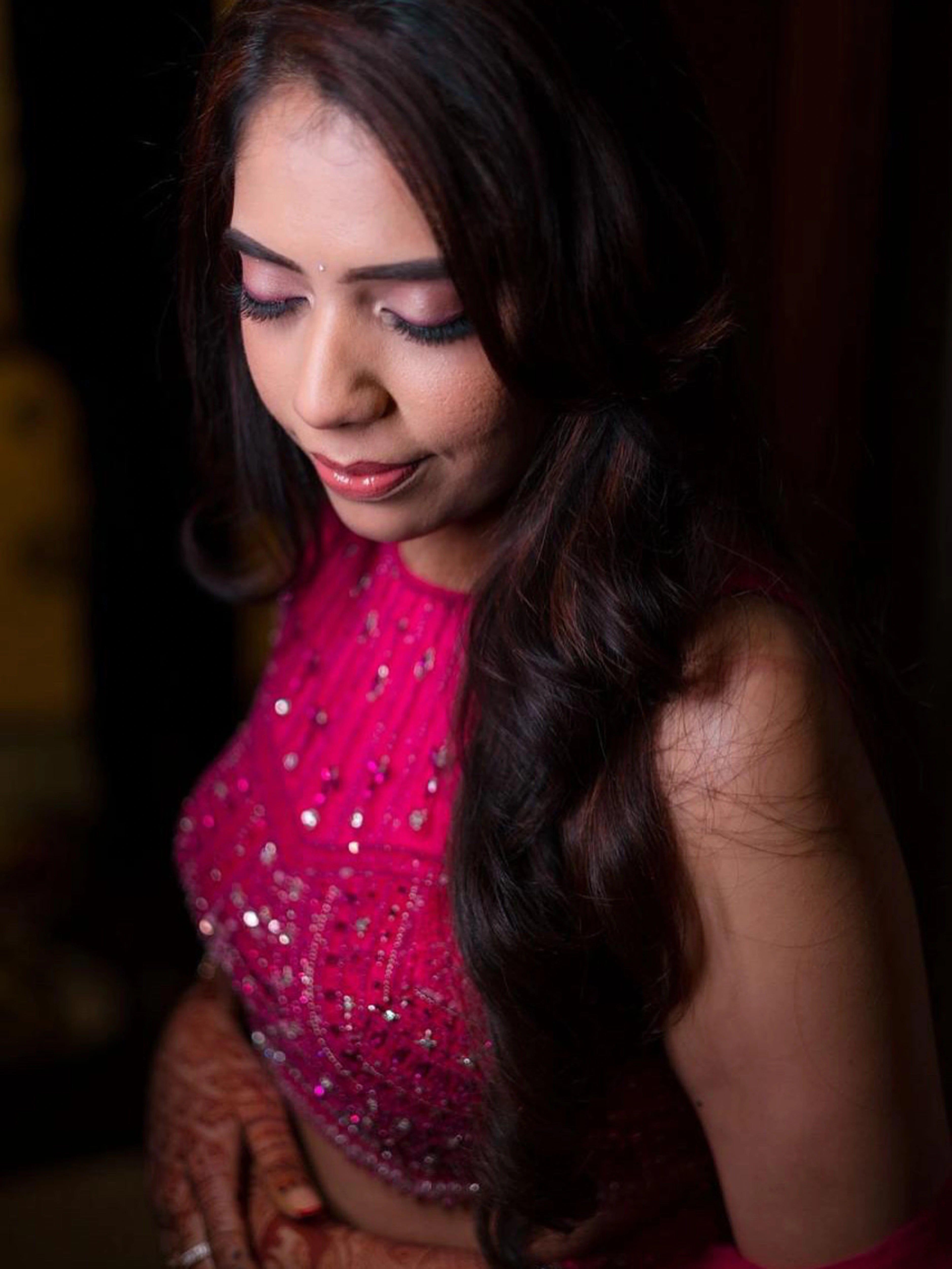 Bride smiling in a pink tulle mermaid lehenga, intricately handcrafted by team Archana Karthick
