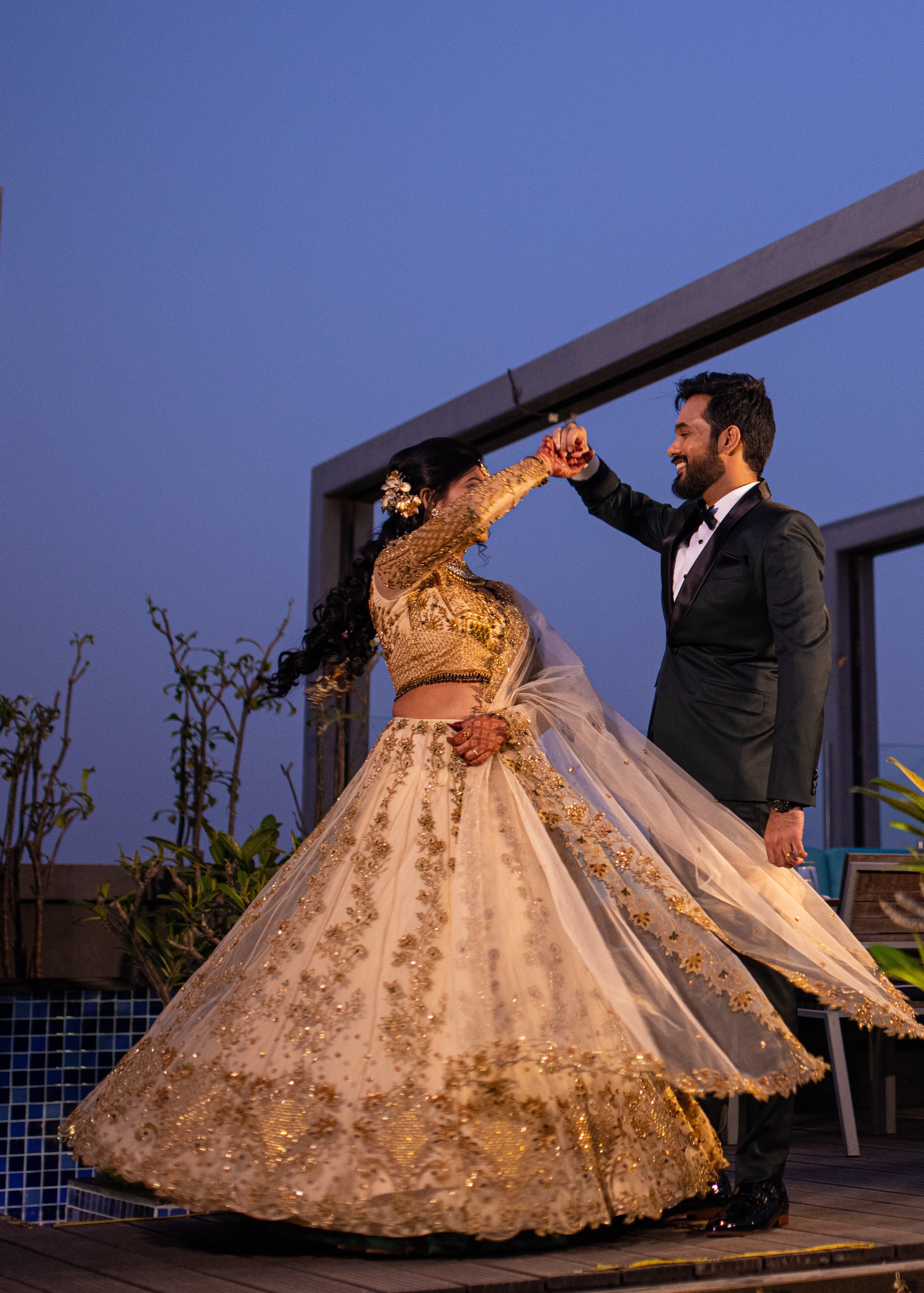Bride twirling with groom in an ivory lehenga in tulle with cut worked dupatta and handcrafted intricately with stones, zardozi, reshams knot work, beads and cutdanas. Designed by Archana Karthick
