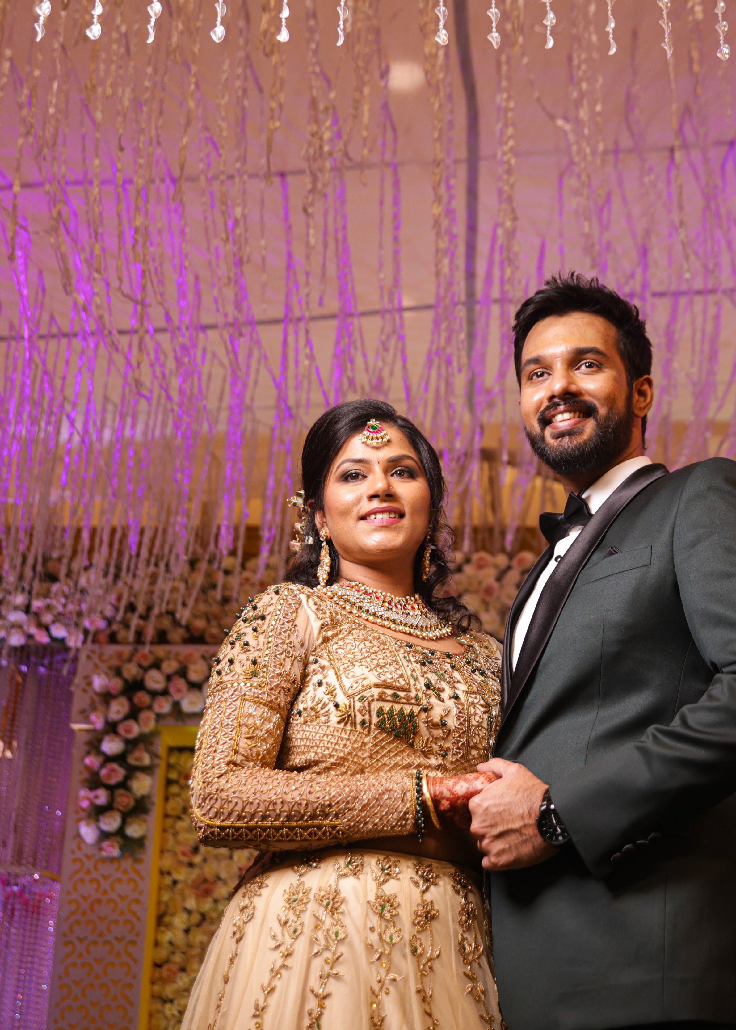 Bride with groom in an ivory lehenga in tulle with cut worked dupatta and handcrafted intricately with stones, zardozi, reshams knot work, beads and cutdanas. Designed by Archana Karthick