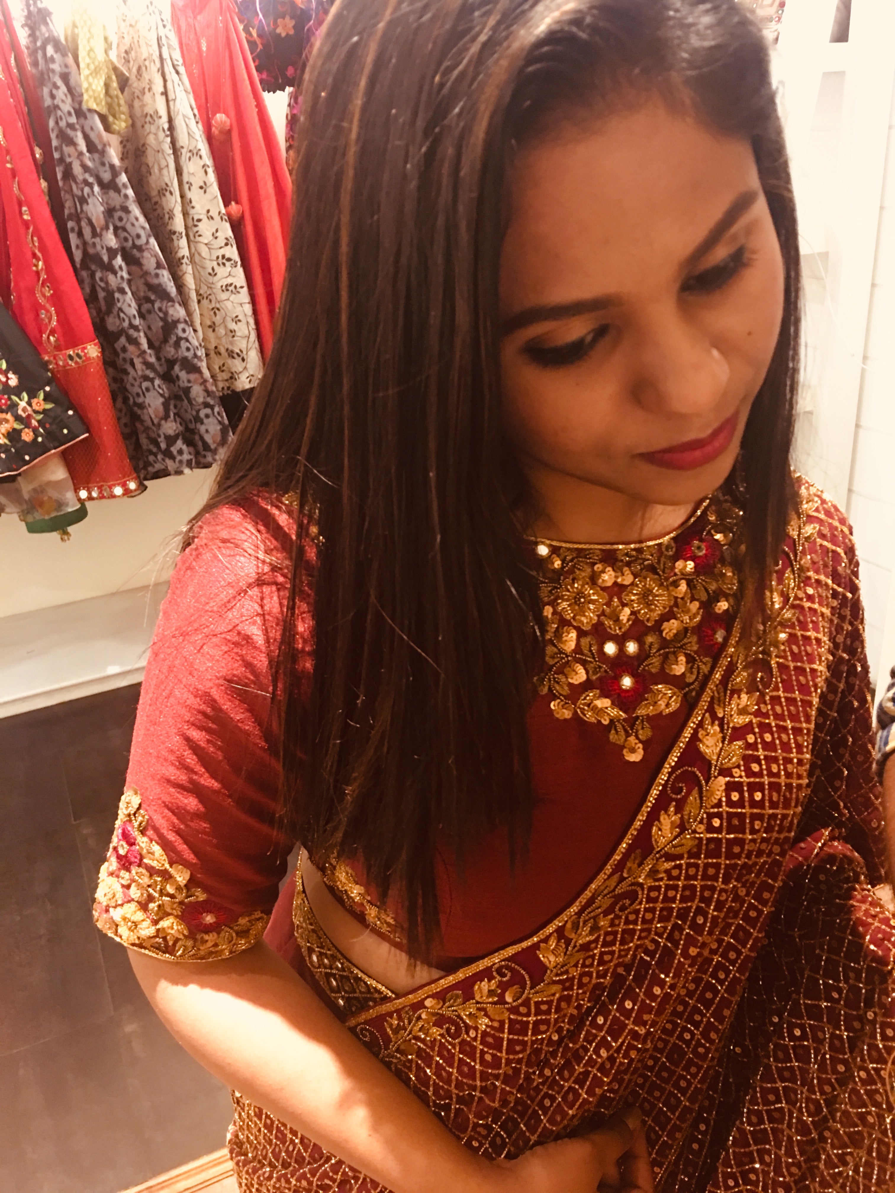 Bridesmaid Abhinaya from Trichy smiling in a wine red rawsilk and tulle lehenga handcrafted with resham, beads, zardozi and mirror work designed by Archana Karthick.