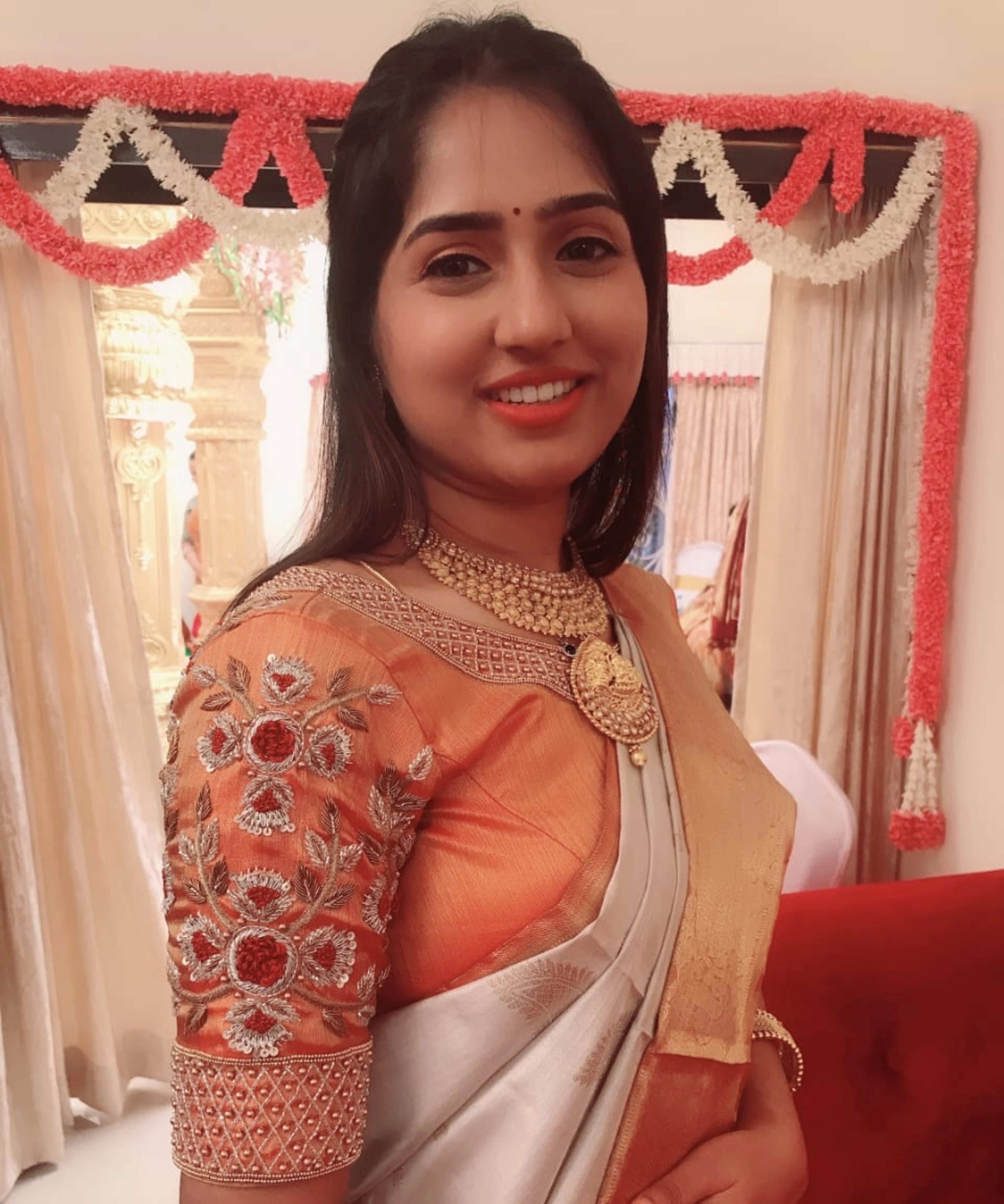Bridesmaid Dr Nivetha from Bangalore in an orange silk blouse, handcrafted by team Archana Karthick.