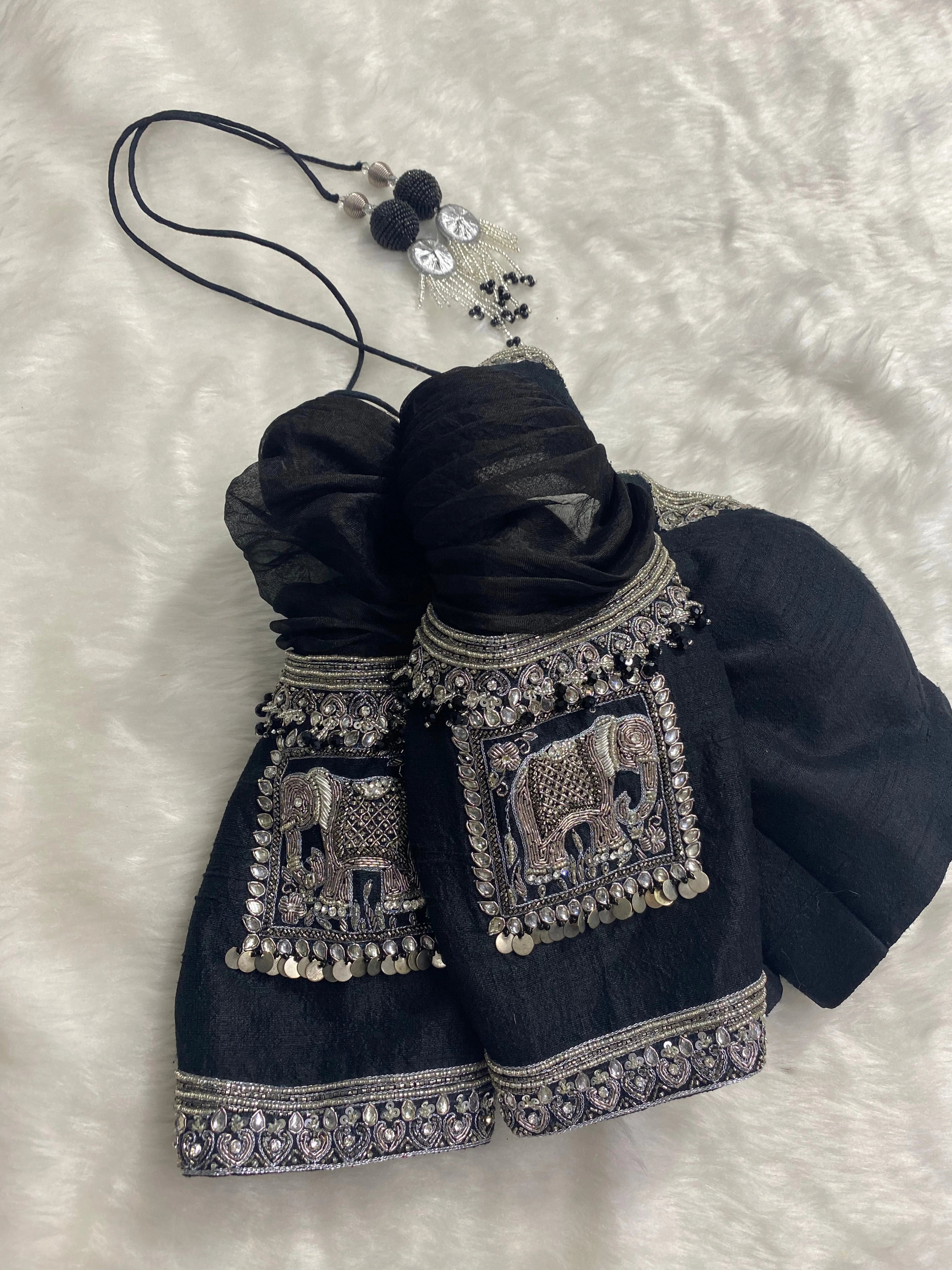 Bridesmaid Nagalakshmi's black rawsilk blouse, handcrafted by team Archana Karthick.