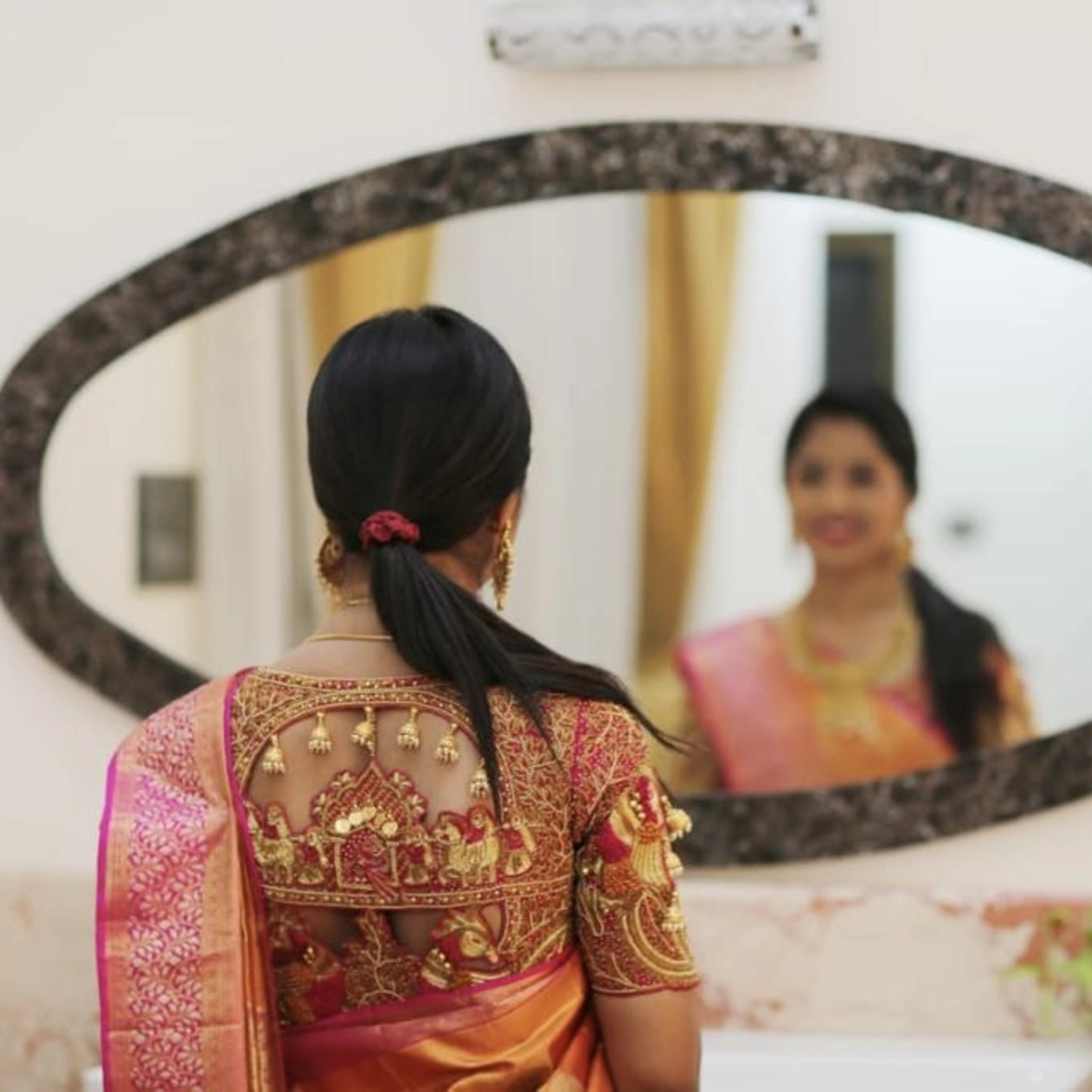 Bridesmaid Nivetha posing in a palanquin concept raspberry silk blouse, intricately handcrafted with zardozi, beads, resham, coins and more by team Archana Karthick.