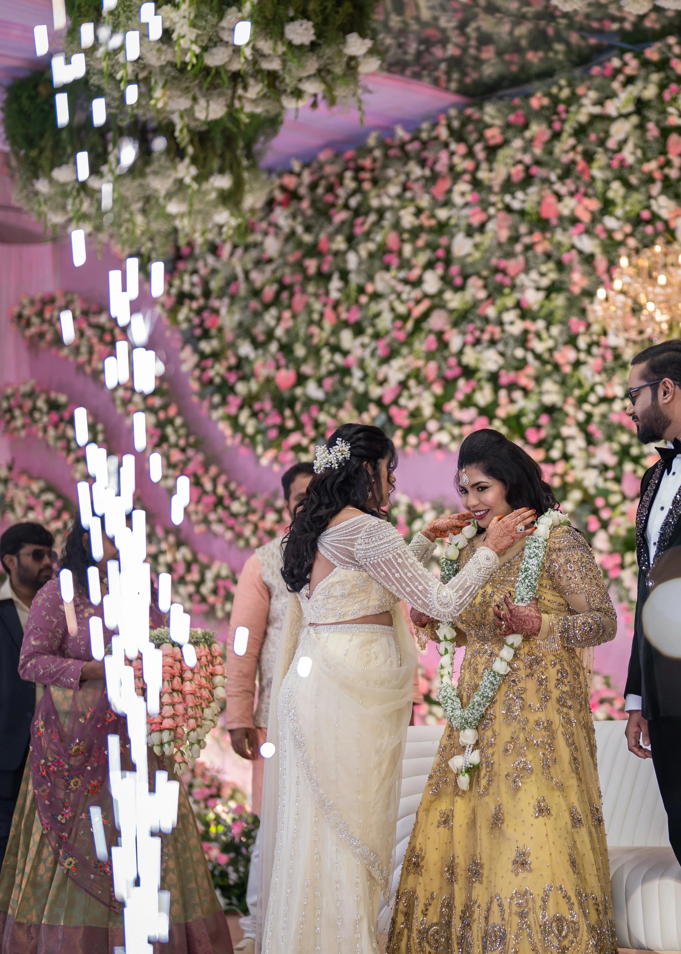 Bridesmaid Sanjana Sujith on stage in a white mermaid tulle draped lehenga by team Archana Karthick.