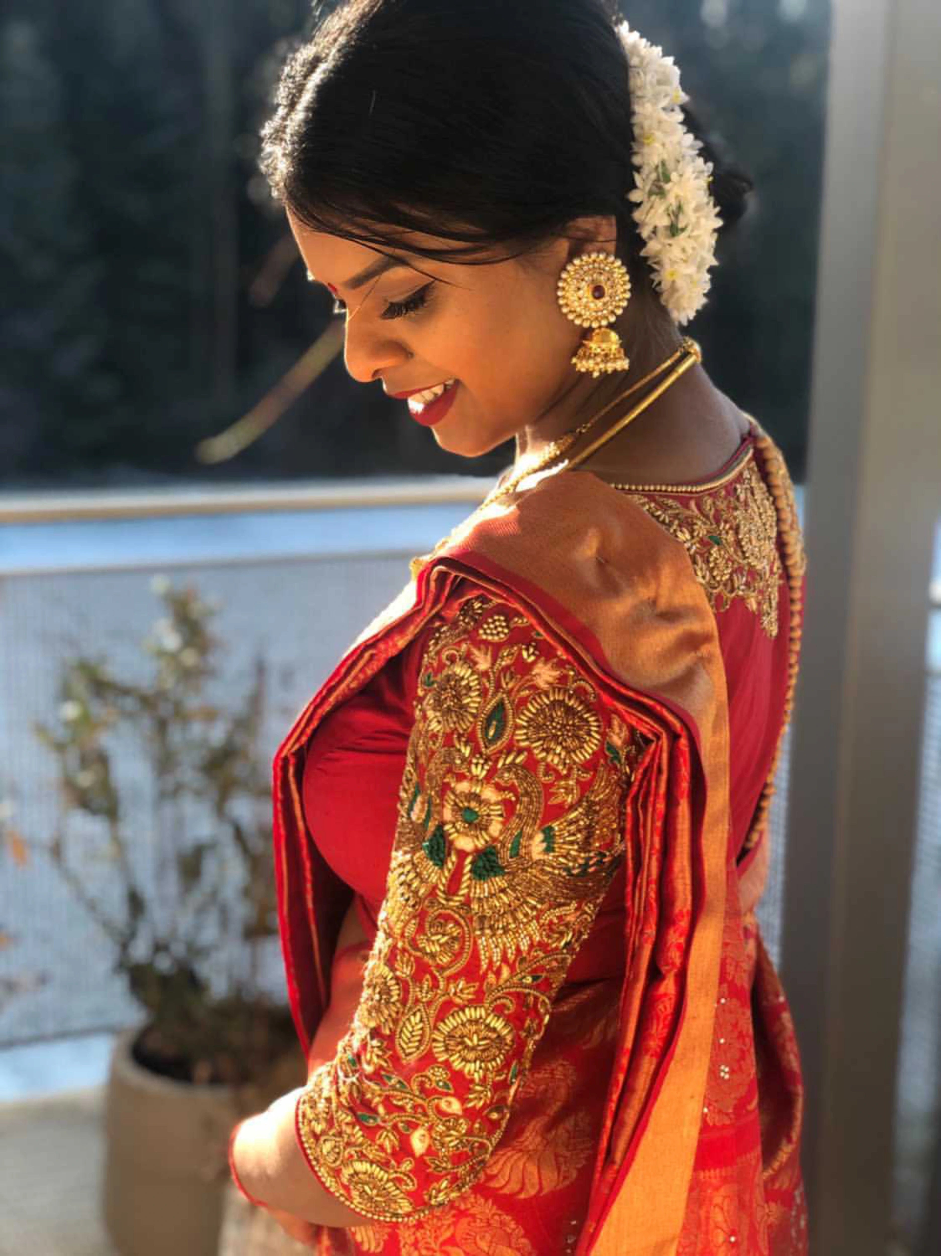 Bridesmaid Shana from Switzerland in a red silk blouse, handcrafted by team Archana Karthick.