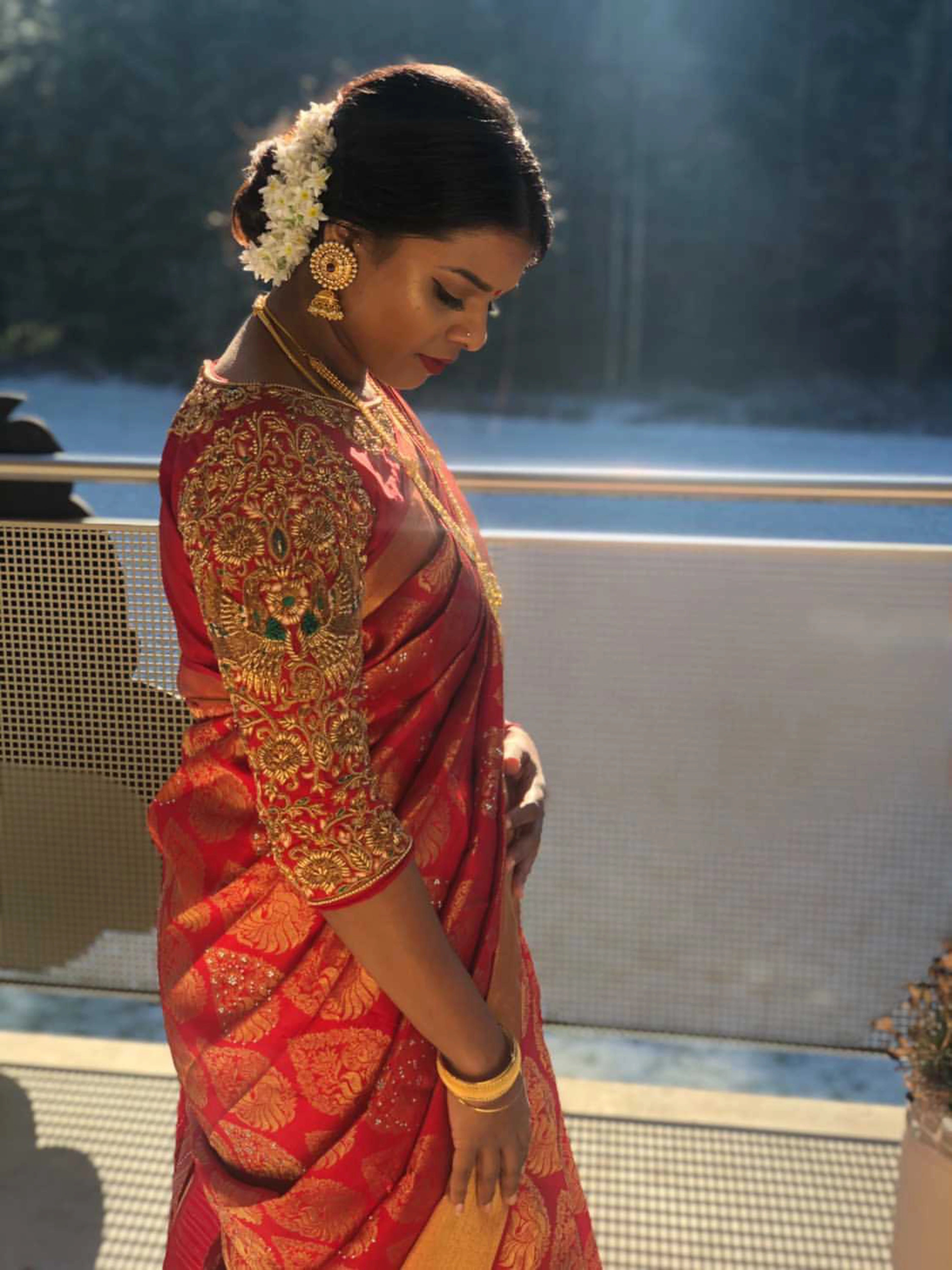Bridesmaid Shana from Switzerland posing in a red silk blouse, handcrafted by team Archana Karthick.