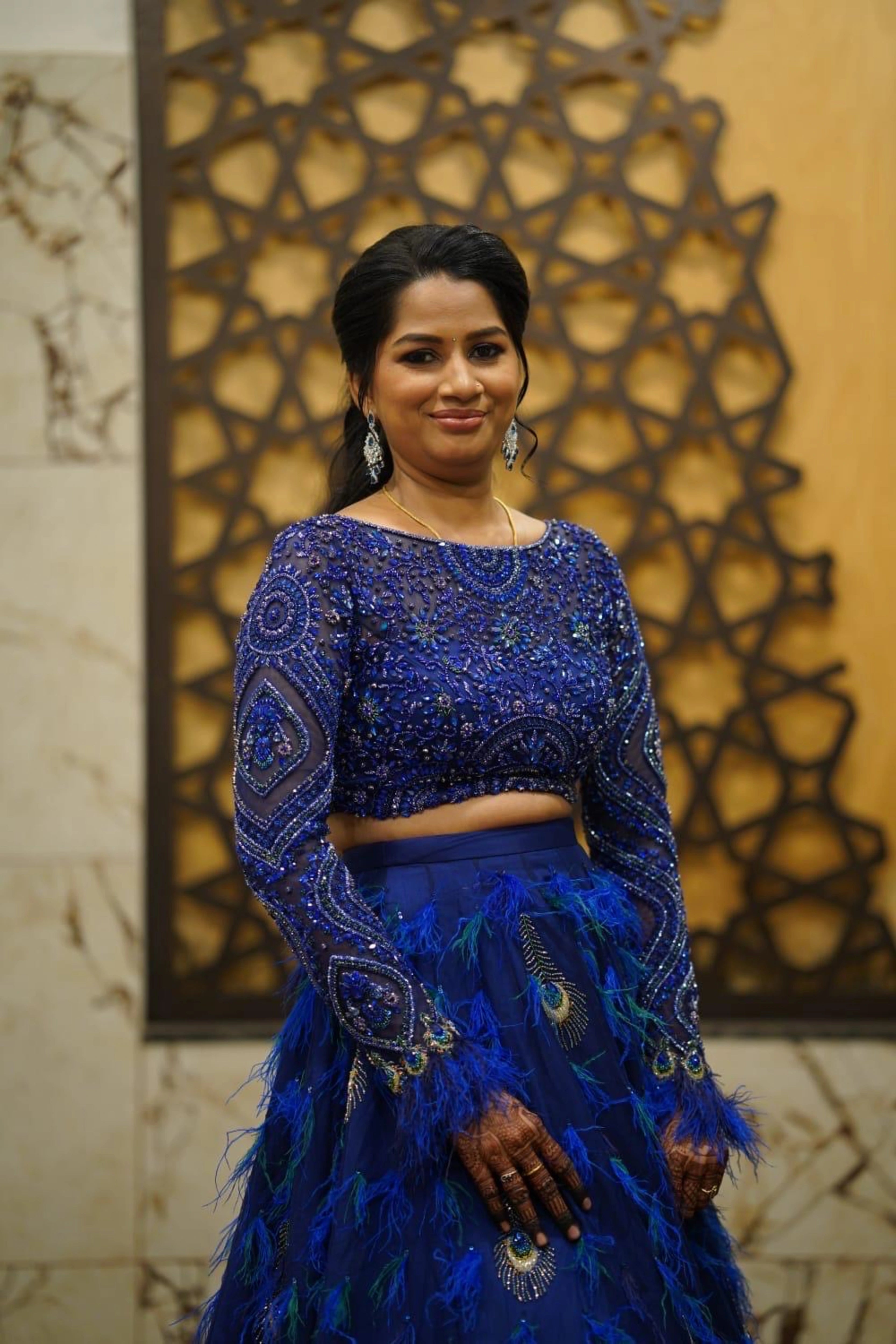 Bridesmaid Sowmiya Rajeev from Singapore, posing in a peacock lehenga by team Archana Karthick