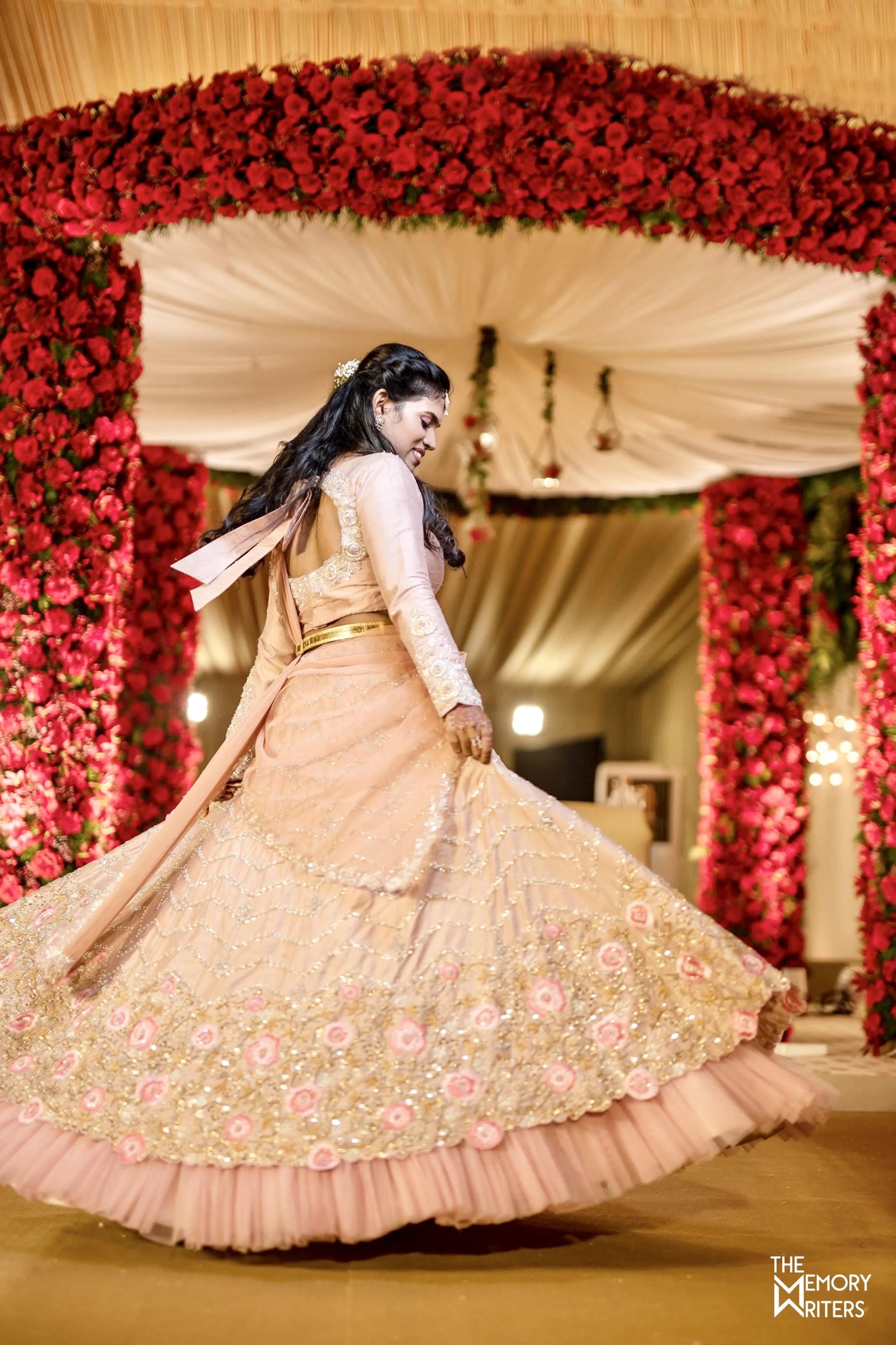 Bridesmaid Sushma mid twirl in a handcrafted blush pink / peach cream rawsilk lehenga with resham, cutdana, sequins and stones designed by Archana Karthick.