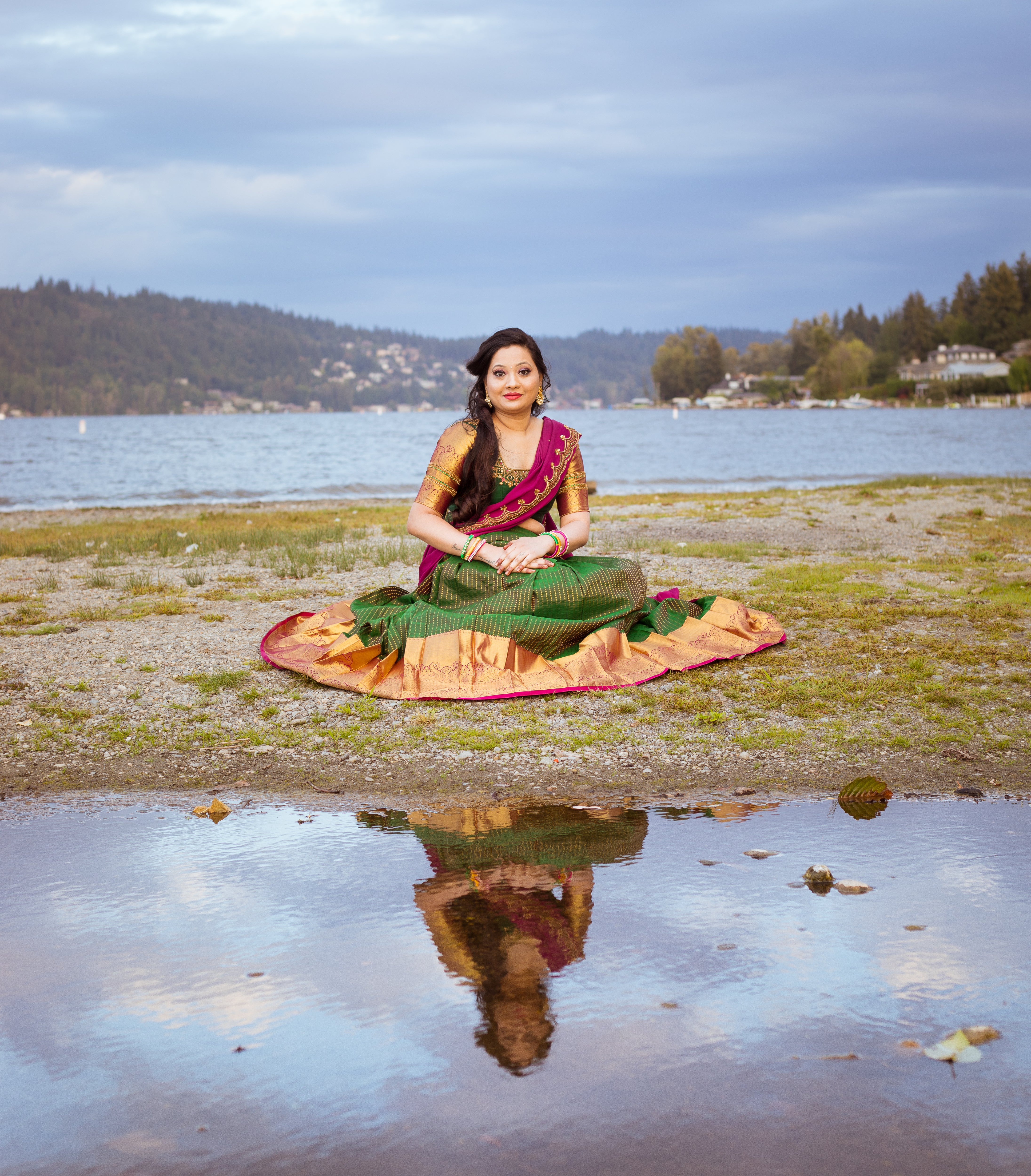 Client from Seattle posing seated in a bottle green and magenta silk traditional half saree designed by archana karthick