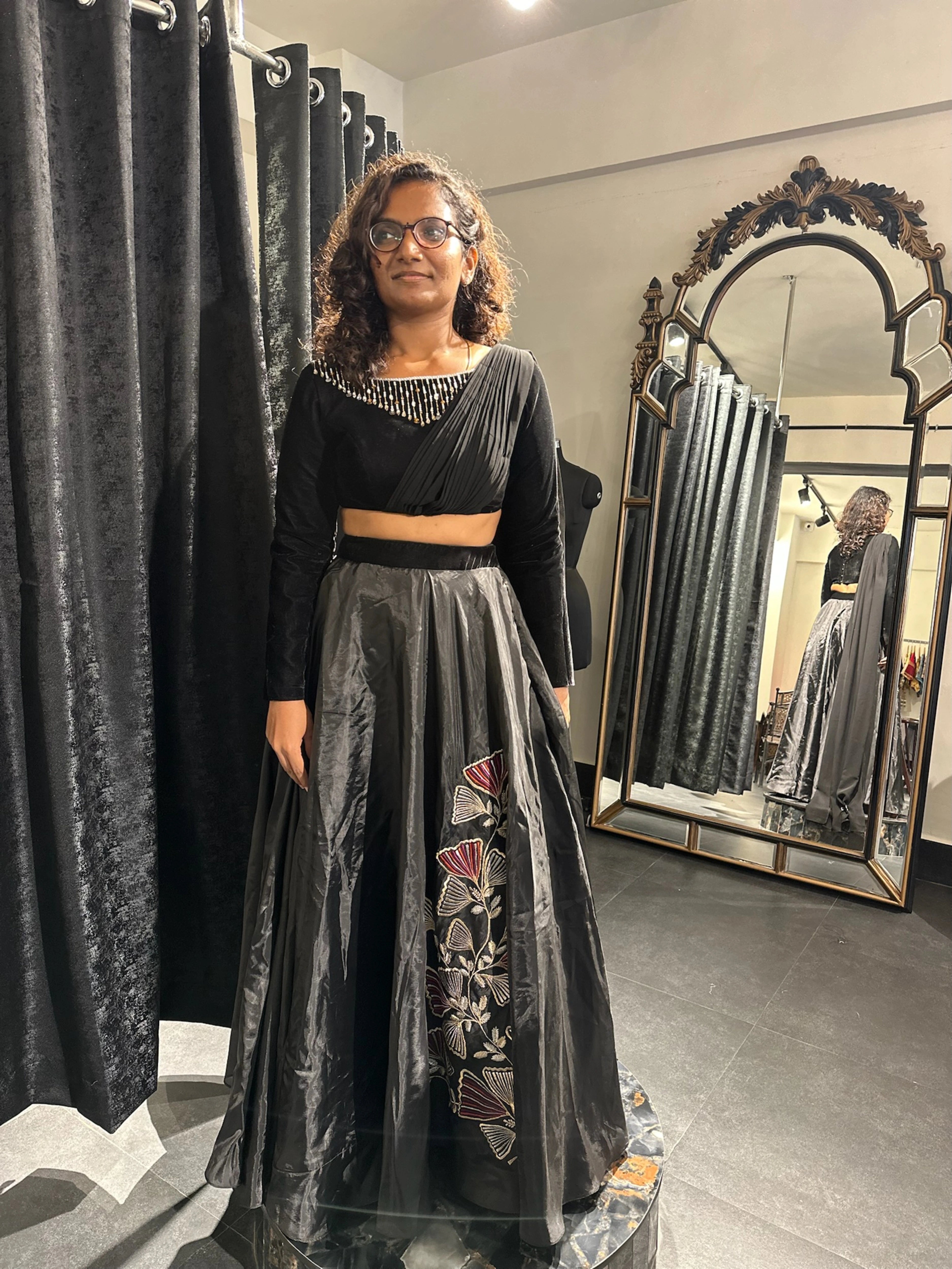 Dr Abinaya in a black dress handcrafted by team Archana Karthick.