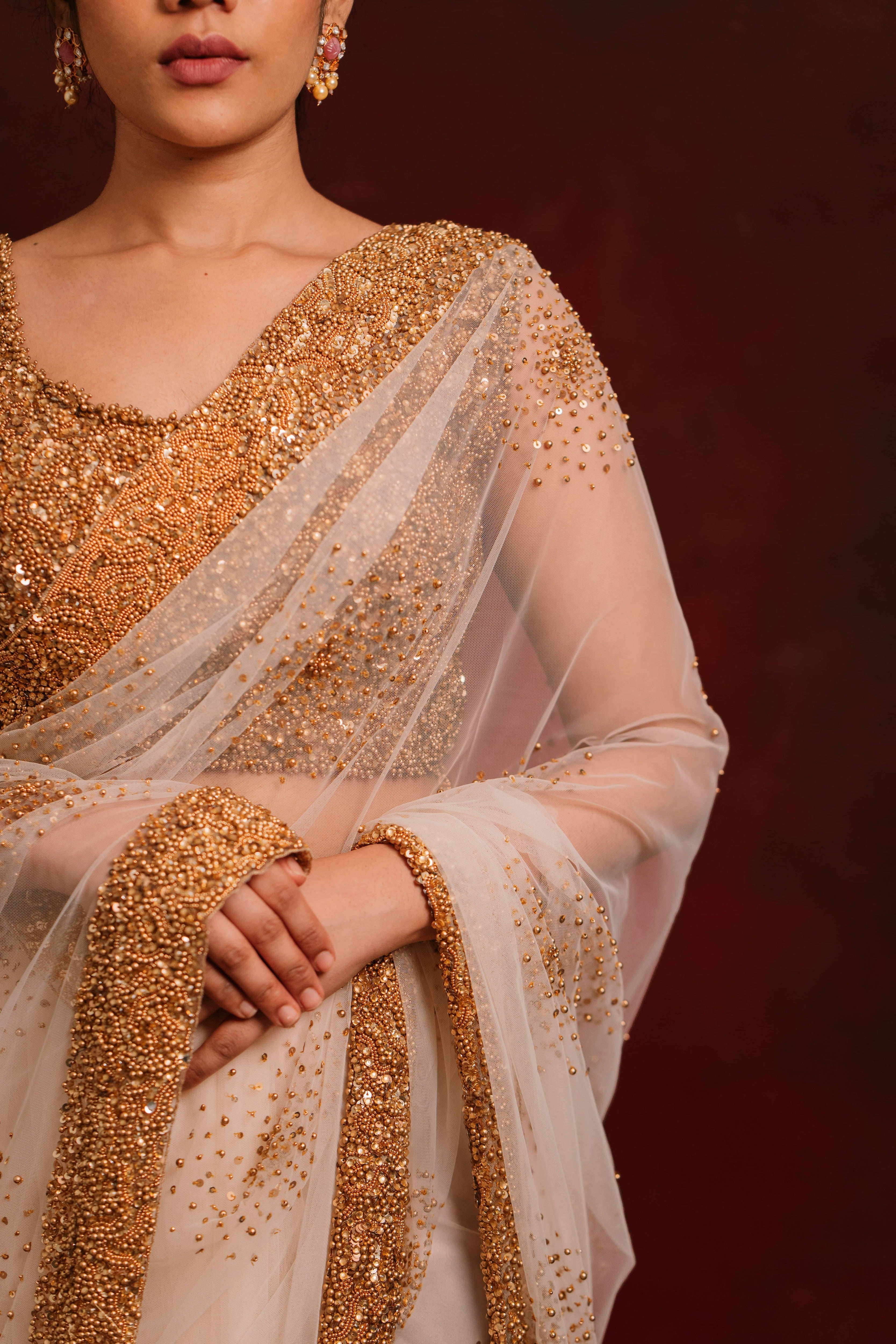 Front and side design details of ivory tulle saree intricately handcrafted with antique gold beads and sequins paired with a handcrafted blouse featuring similar work by team Archana Karthick