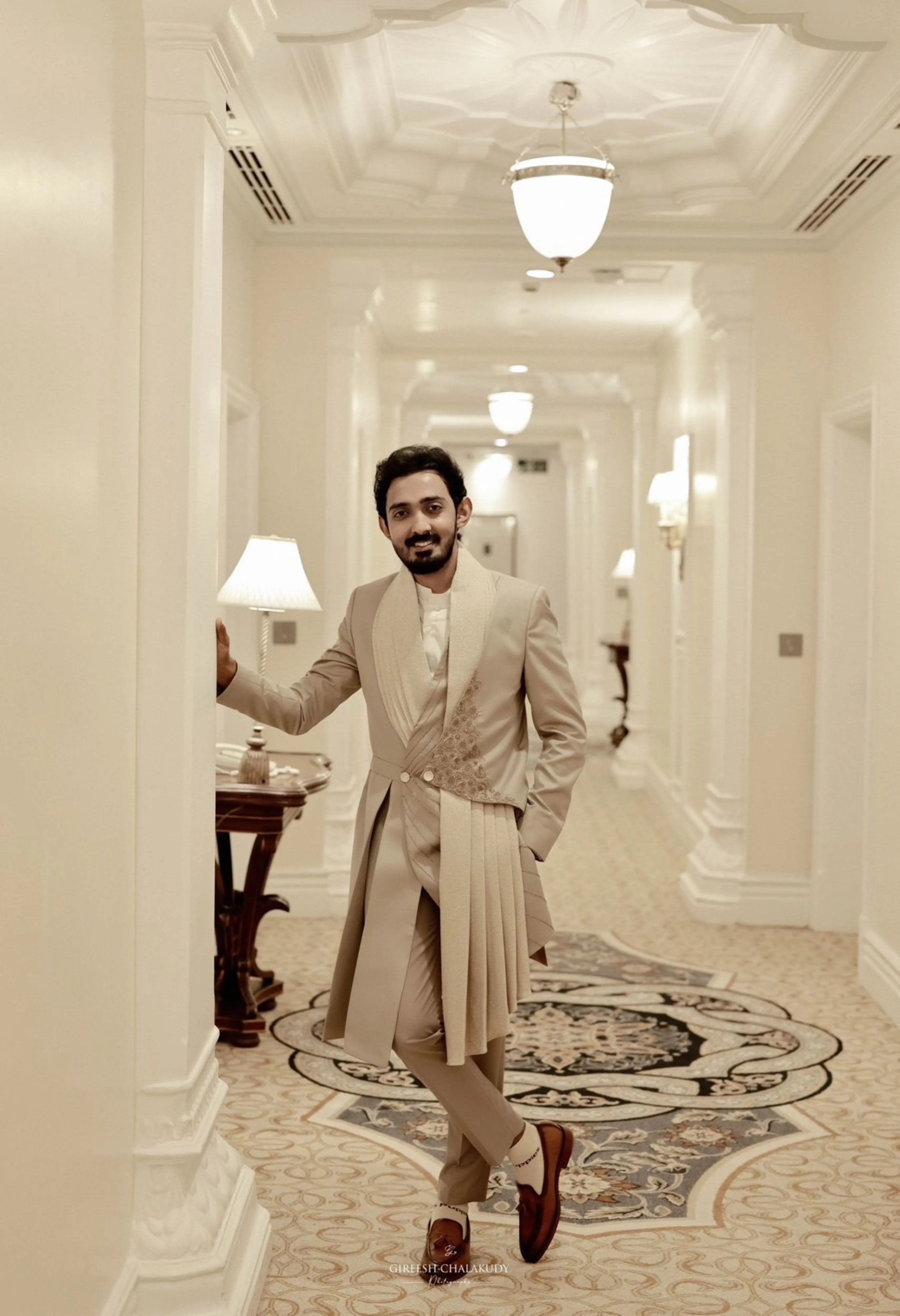 Groom Dr Mehal from Cochin smiling in a beige indowestern sherwani handcrafted by team Archana Karthick.