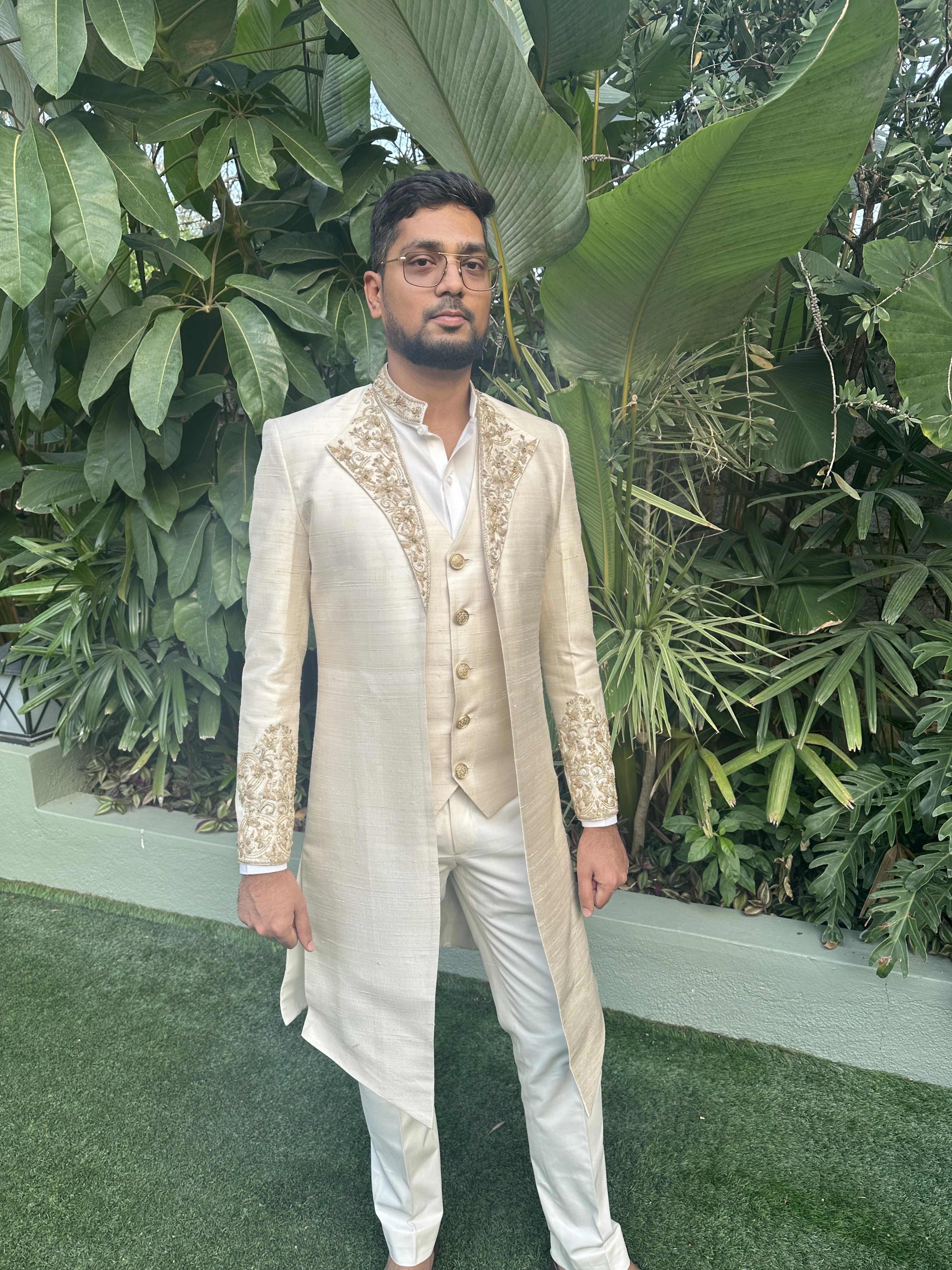 Groom Mahesh from bangalore posing in an ivory raw silk sherwani handcrafted by team Archana Karthick.