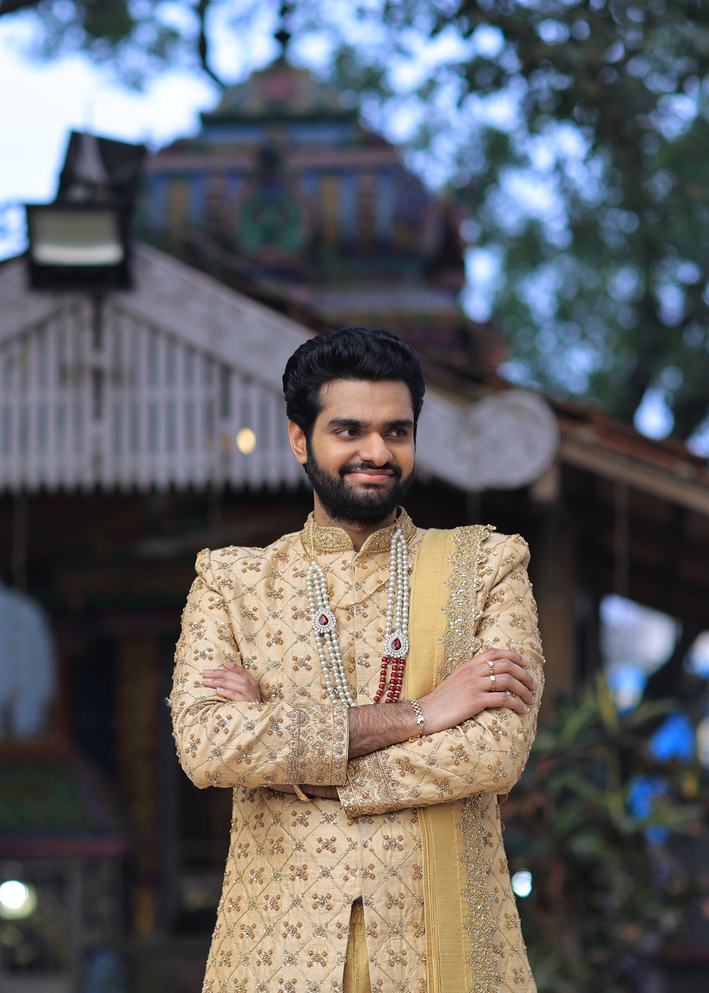 Groom from Canada smiling in handcrafted gold sherwani by Archana Karthick