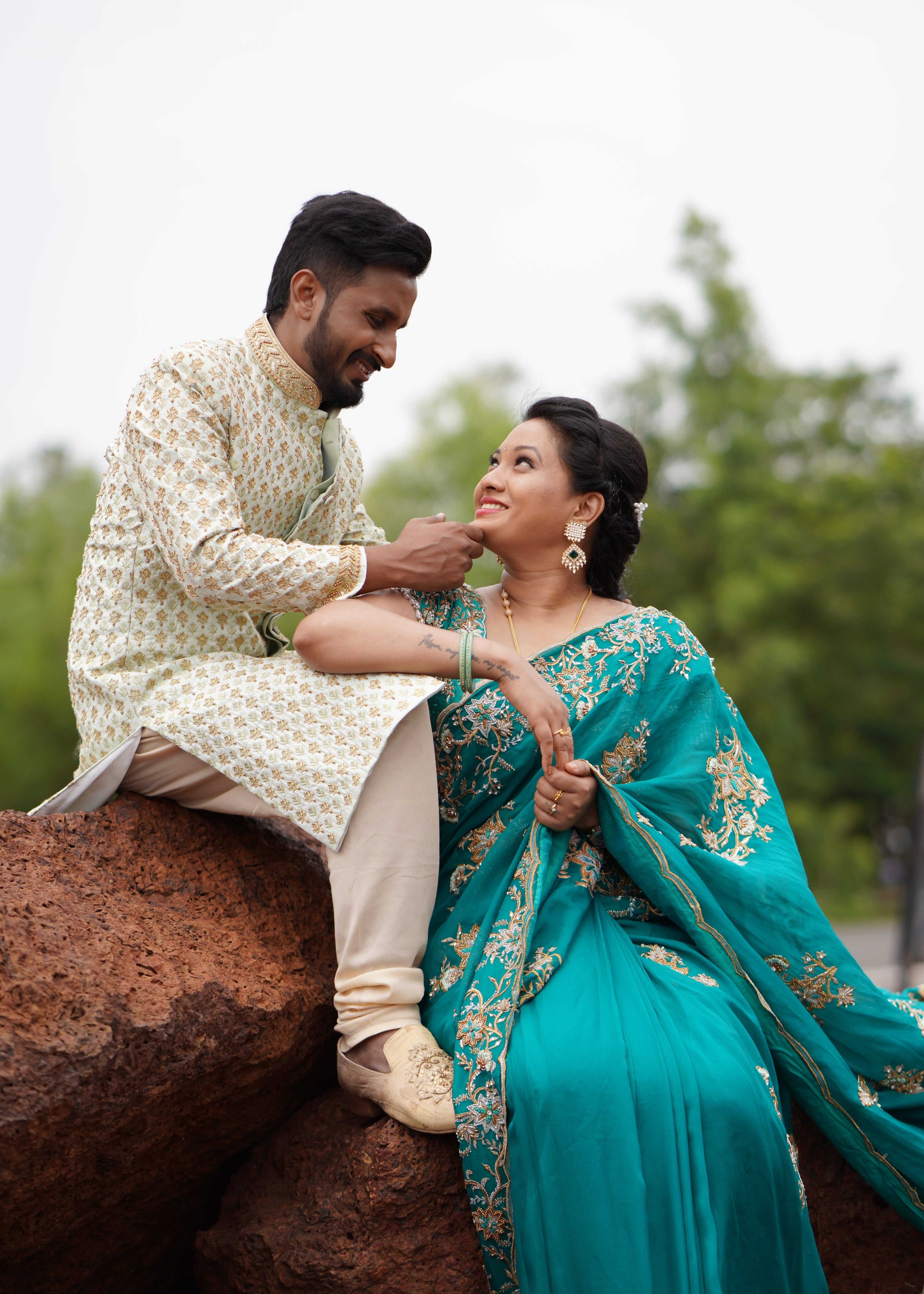 Groom from Seatlle, posing in a sage green sherwani designed in raw silk for a photoshoot is handcrafted intricately with zardozi, beads and zari. Designed by Archana Karthick.