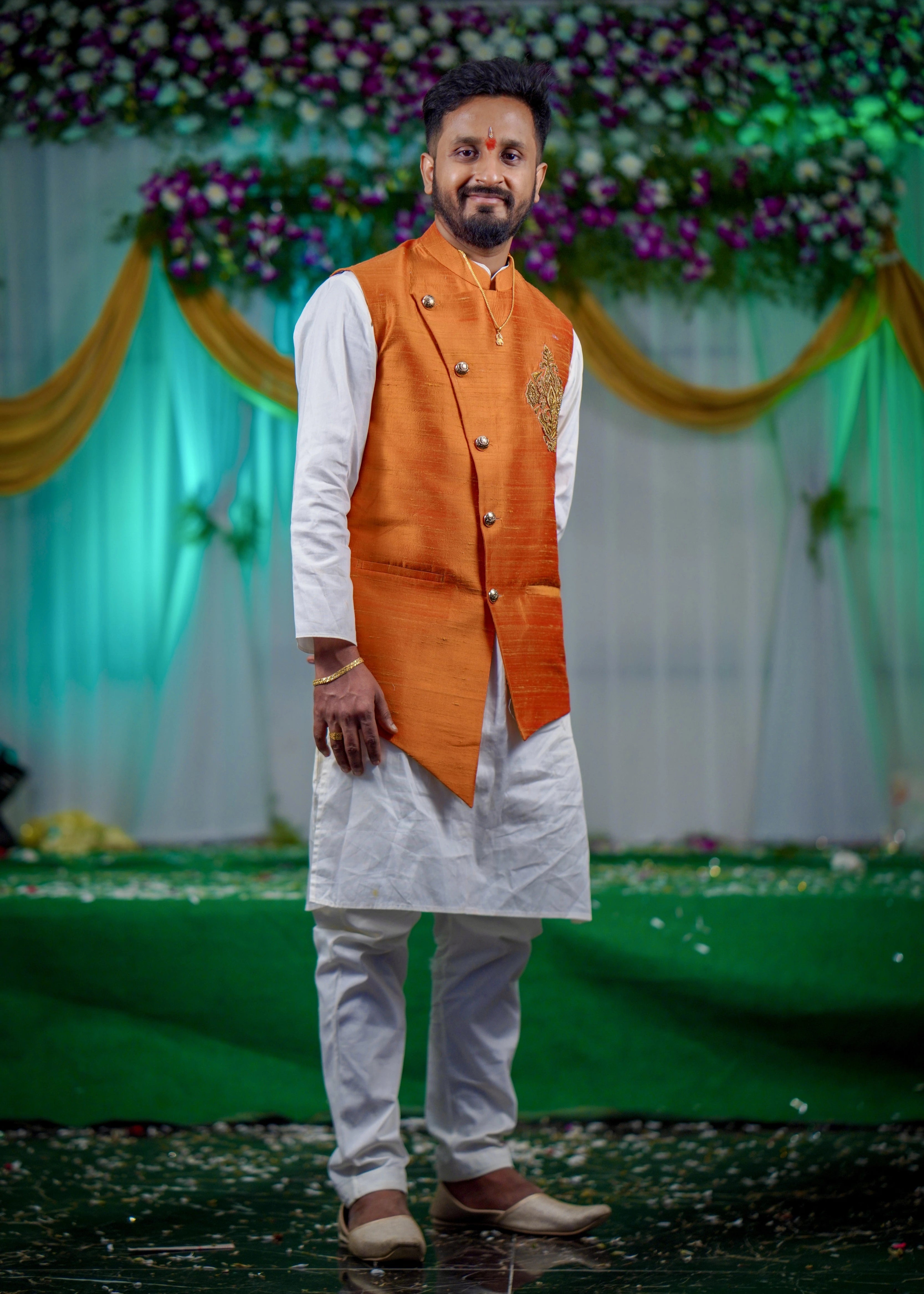 Groom from Seattle, USA posing in a bespoke burnt orange raw silk and handloom bandhgala set by Archana Karthick