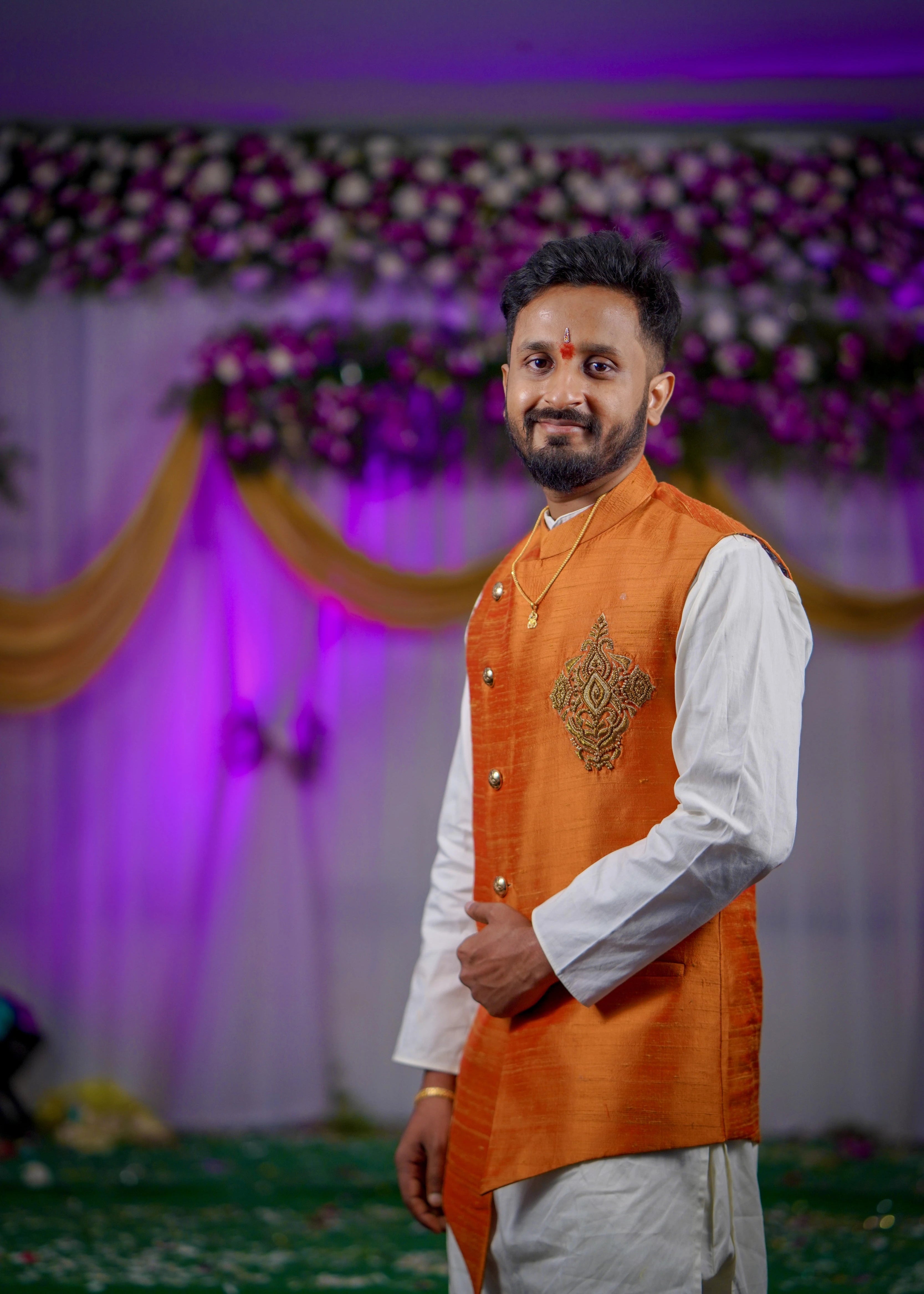 Groom from Seattle, USA smiling in a bespoke burnt orange raw silk and handloom bandhgala set by Archana Karthick