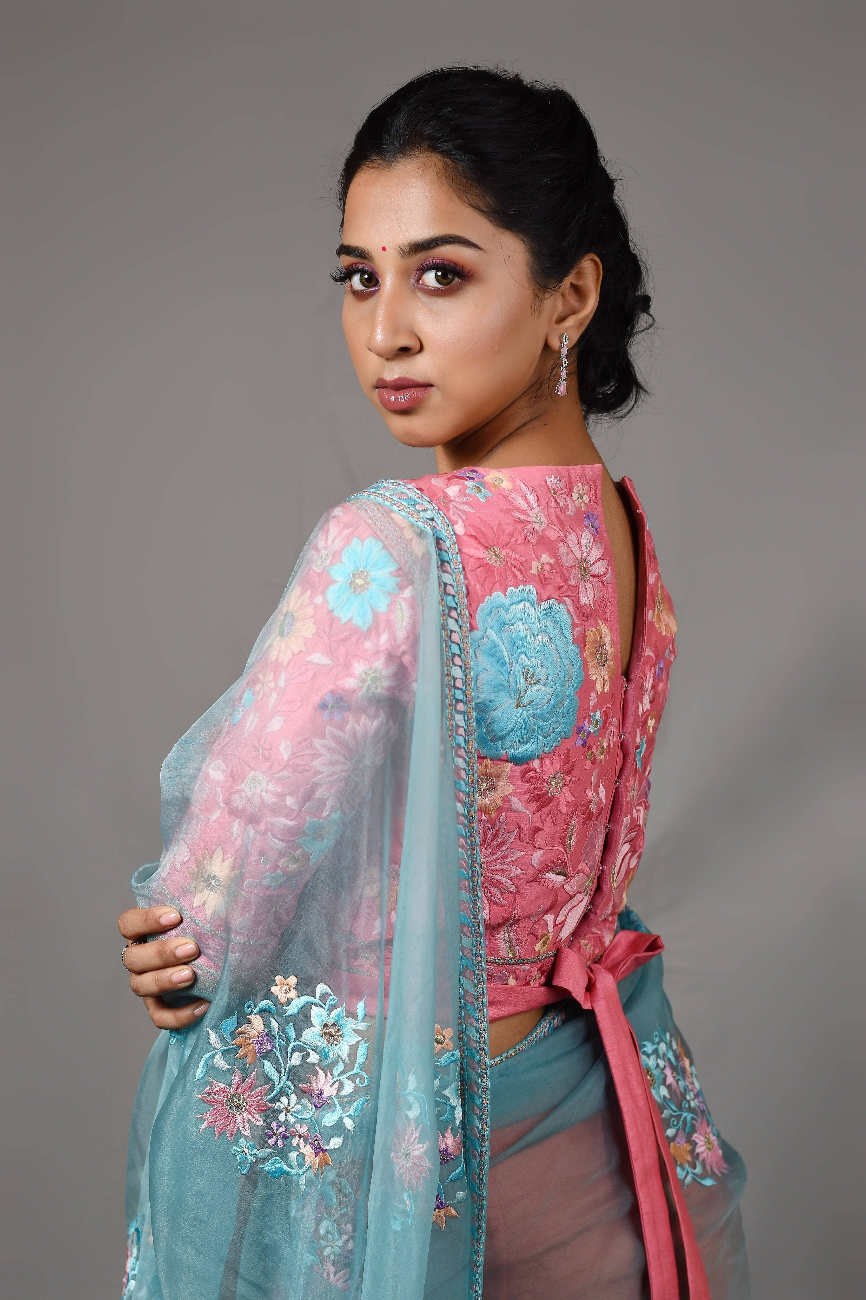Influencer Deekshita Nikkam in powder pink and powder blue organza saree set designed by Archana Karthick. Wait tie up blouse back detailing.