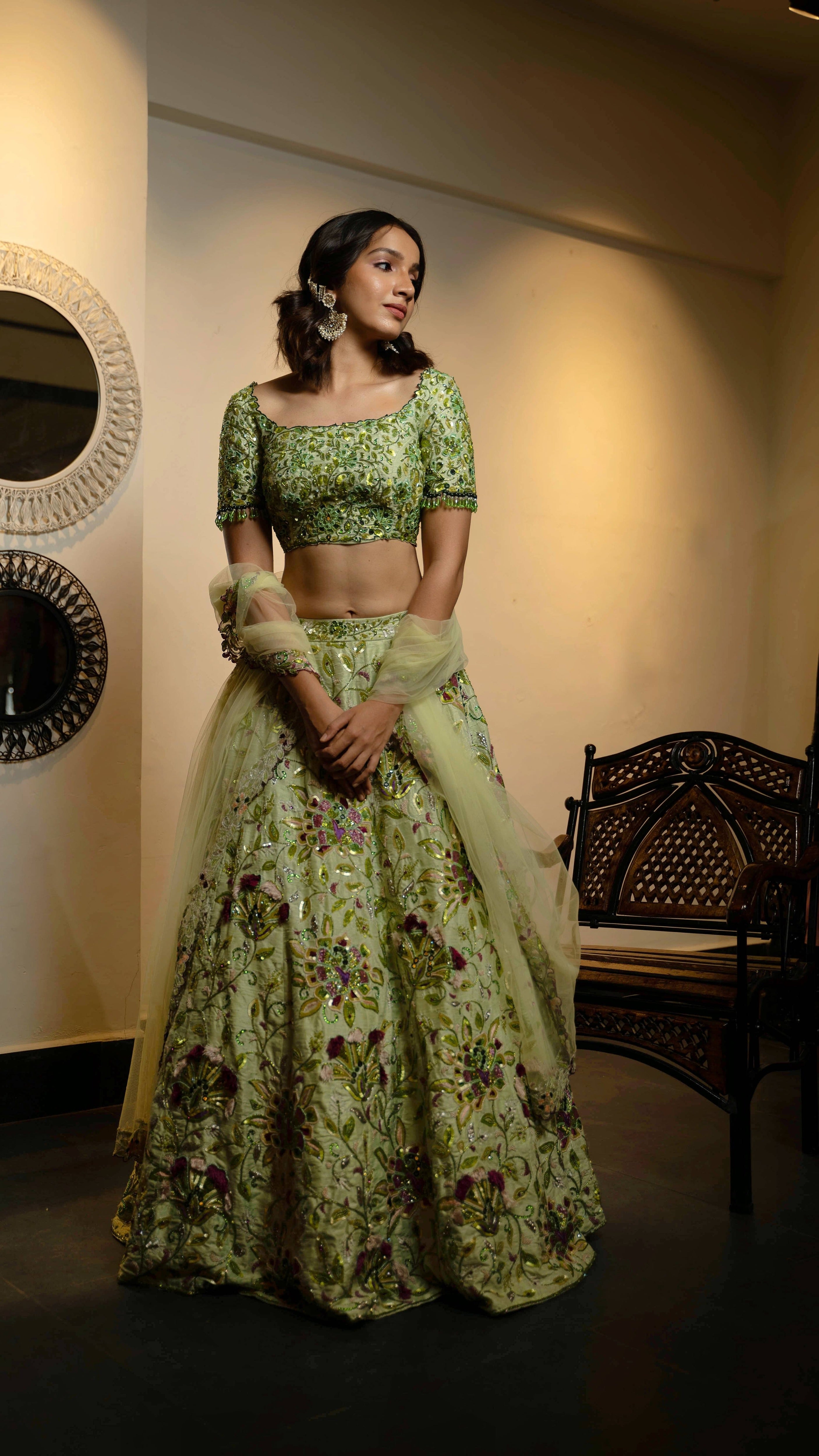 Influencer and actress Shweta Gai in a handcrafted green raw silk lehenga with floral motifs by Archana Karthick. Posing looking to her left.