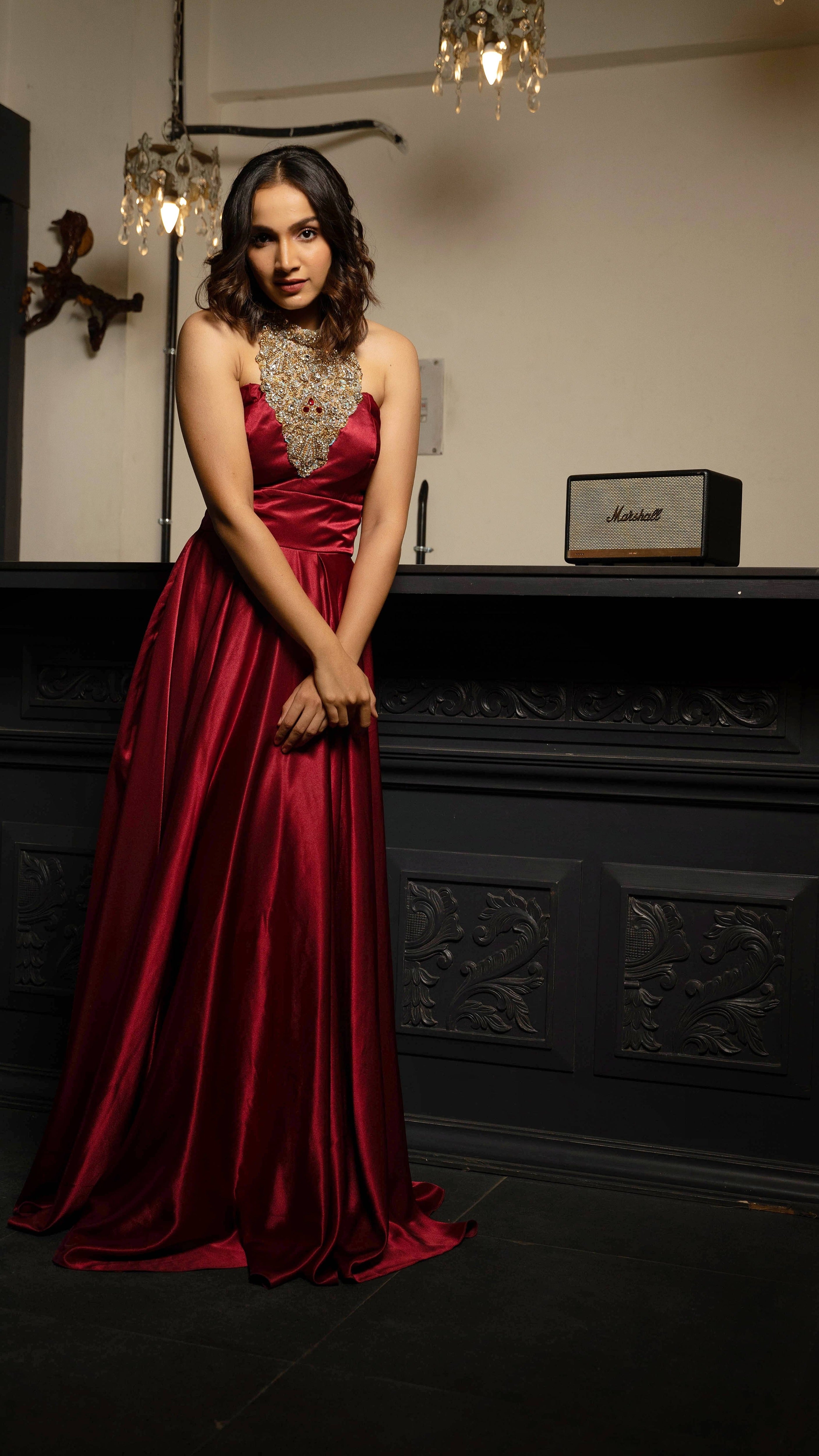 Influencer and actress Shweta Gai in a red satin silk halterneck gown with a heavily embellished neckline.