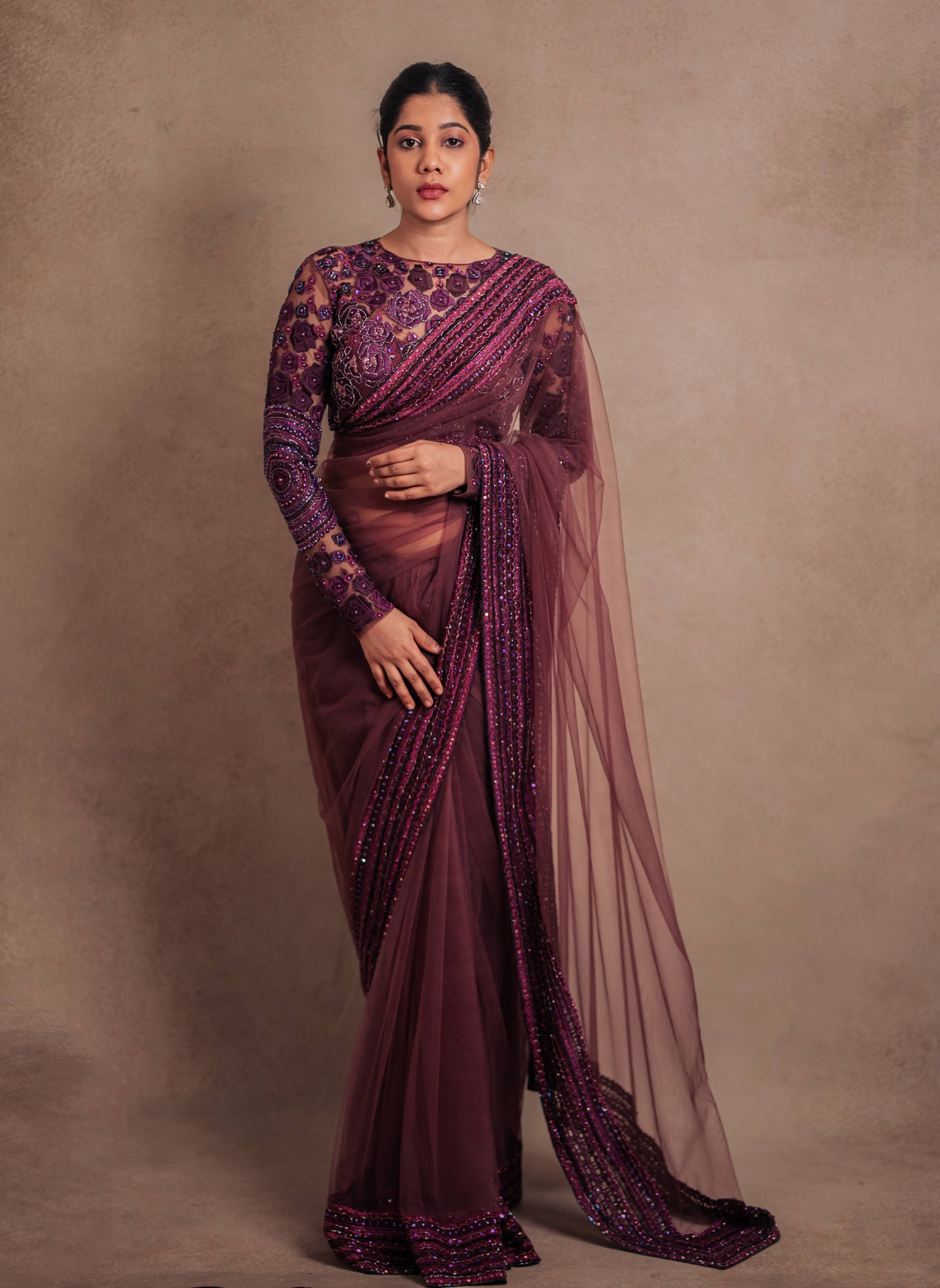 Jaina Parmar, known for recreating looks of actress Nayanthara is seen here in a purple net saree with heavily embellished border and full sleeved blouse with stone and resham work